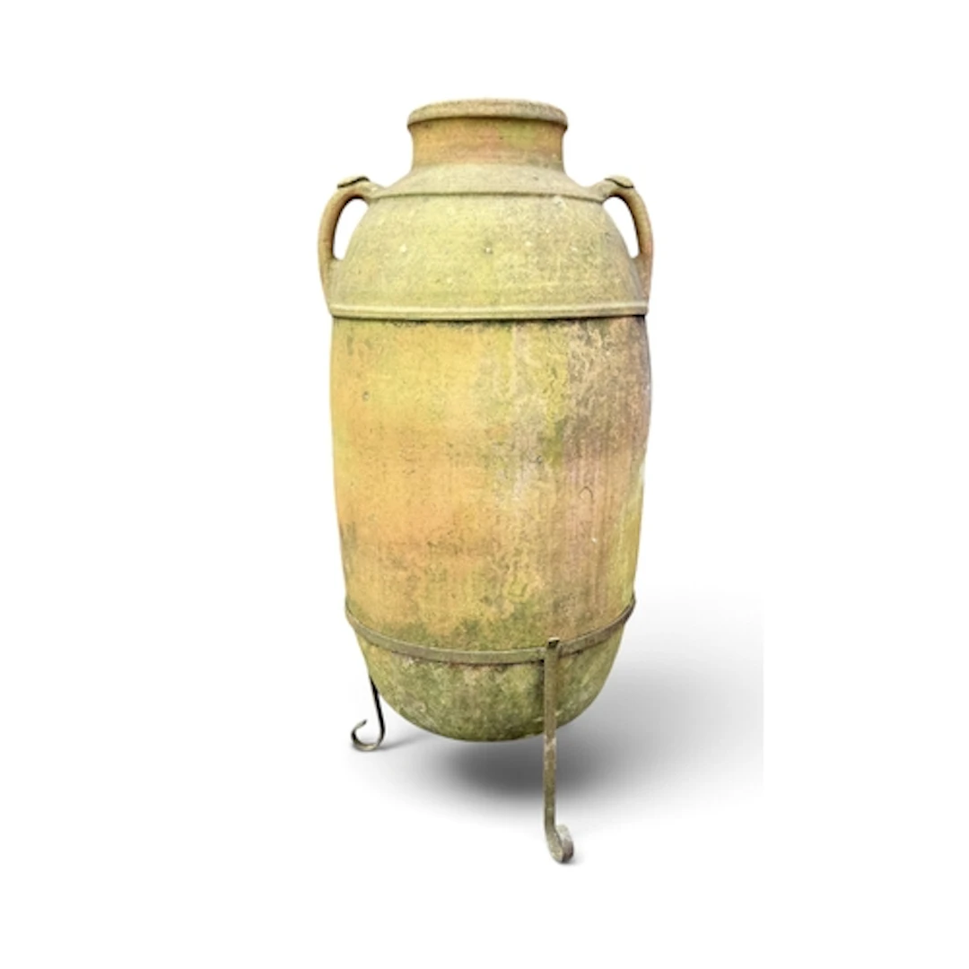 A LARGE TERRACOTTA OLIVE JAR ON STAND The cast iron stand on...