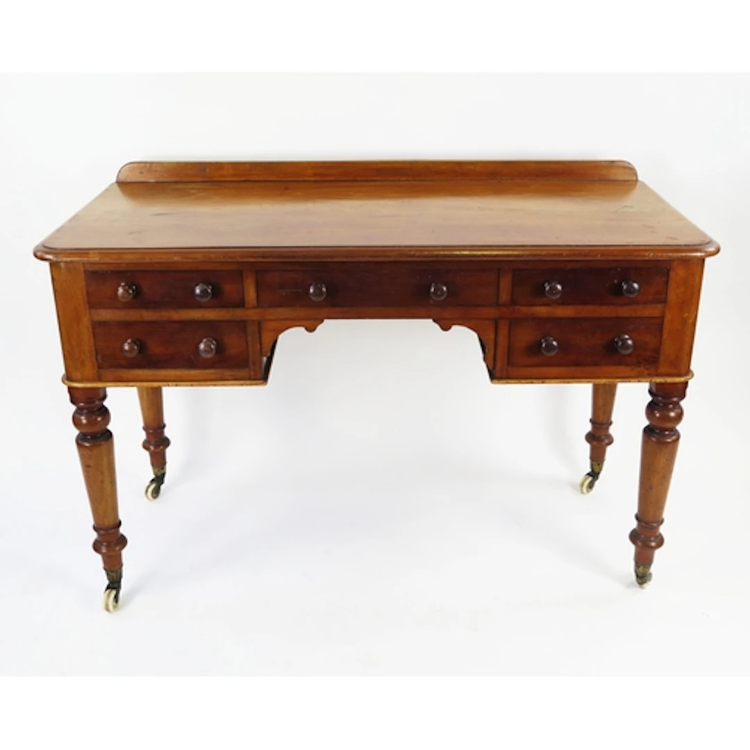 A Victorian mahogany desk with central drawer flanked by fou...