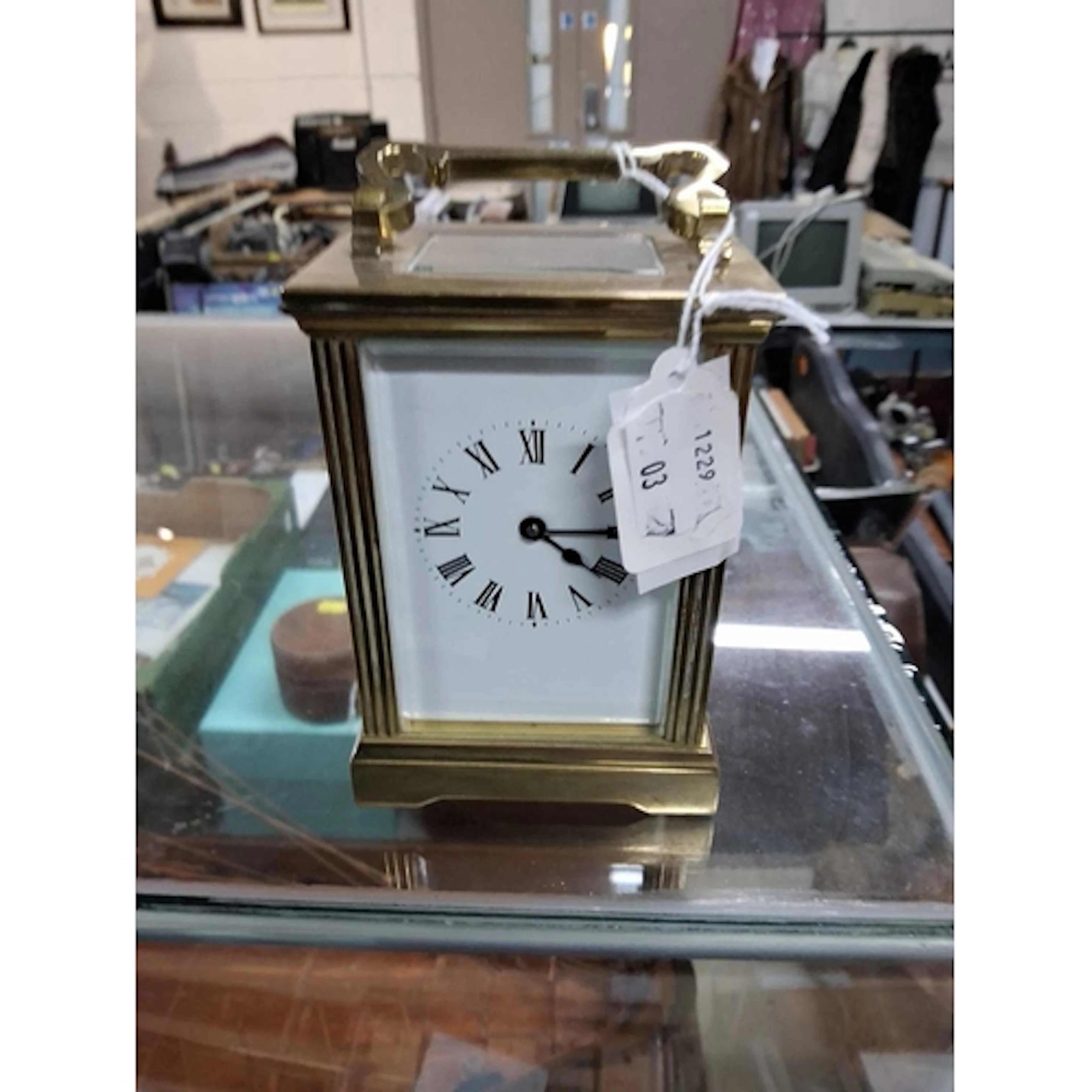 A GILT BRASS CARRIAGE CLOCK, with handle, key wound, white e...