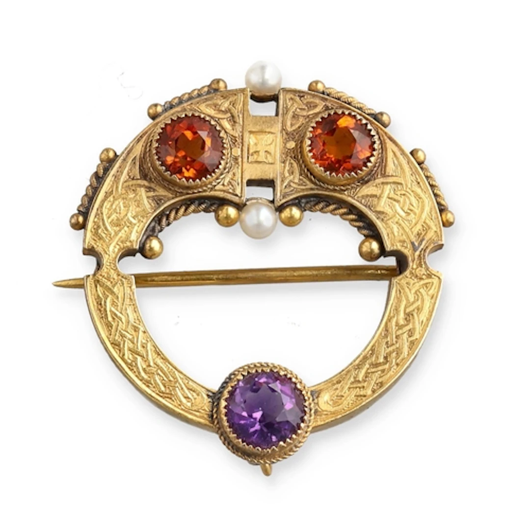 AN ANTIQUE 15CT GOLD CELTIC BROOCH SET WITH AMETHYST AND TWO...