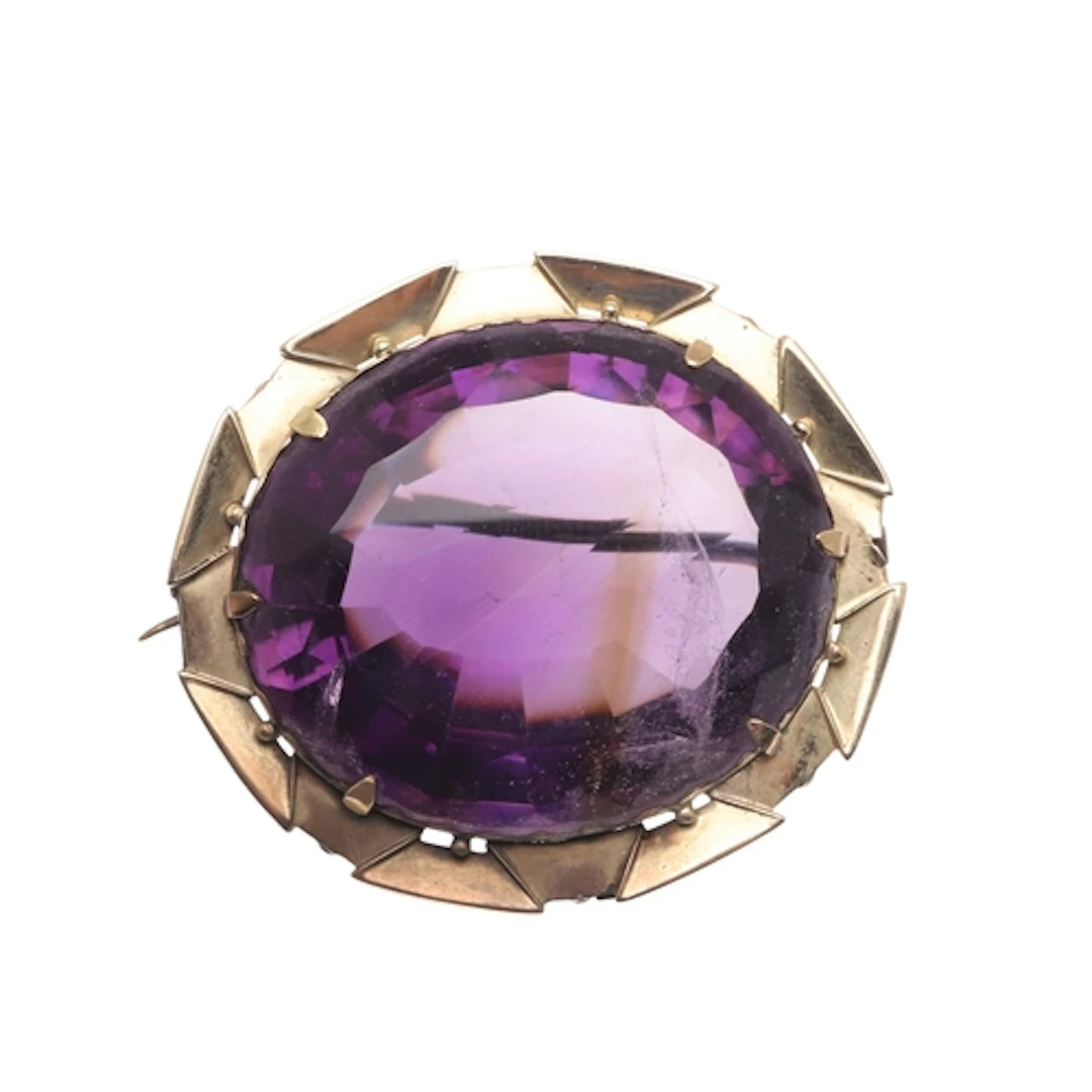 AN AMETHYST AND GOLD BROOCH. the large oval-shaped amethyst ...