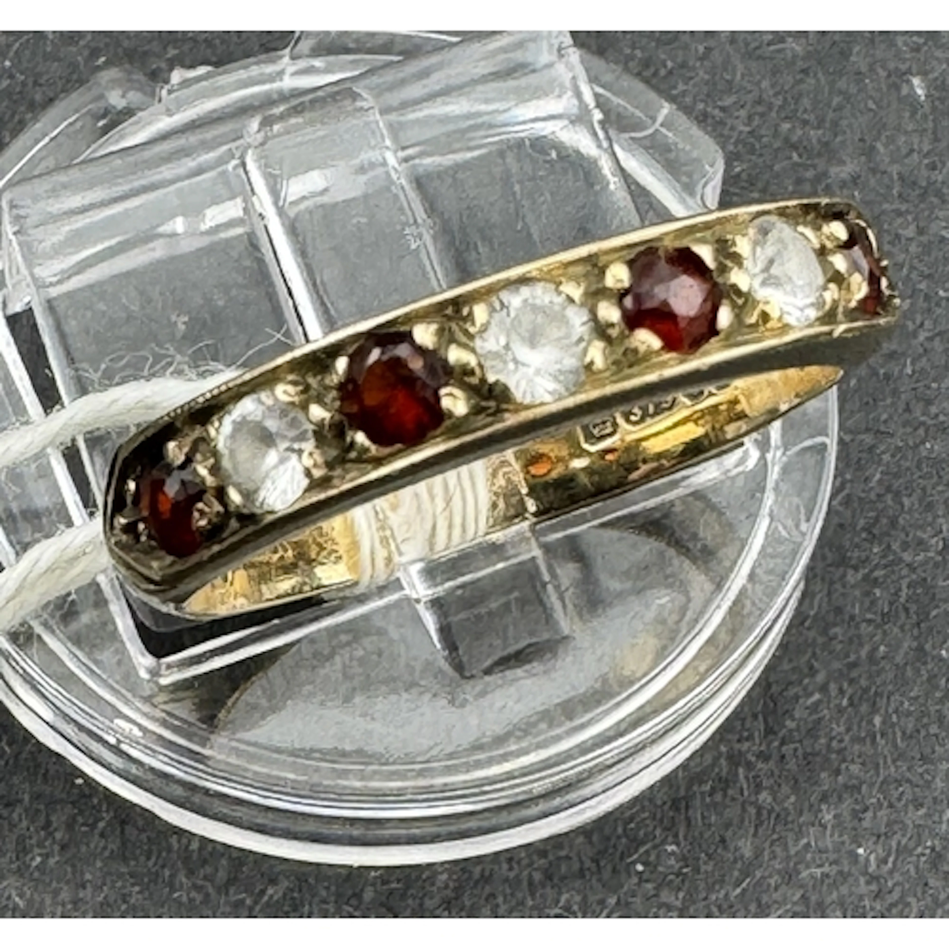 Jewellery: a 9ct yellow gold ring set a row of seven alterna...