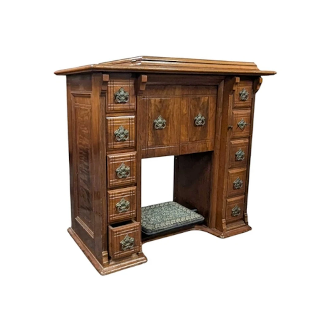 An early 20th century walnut Singer treadle table. The table...