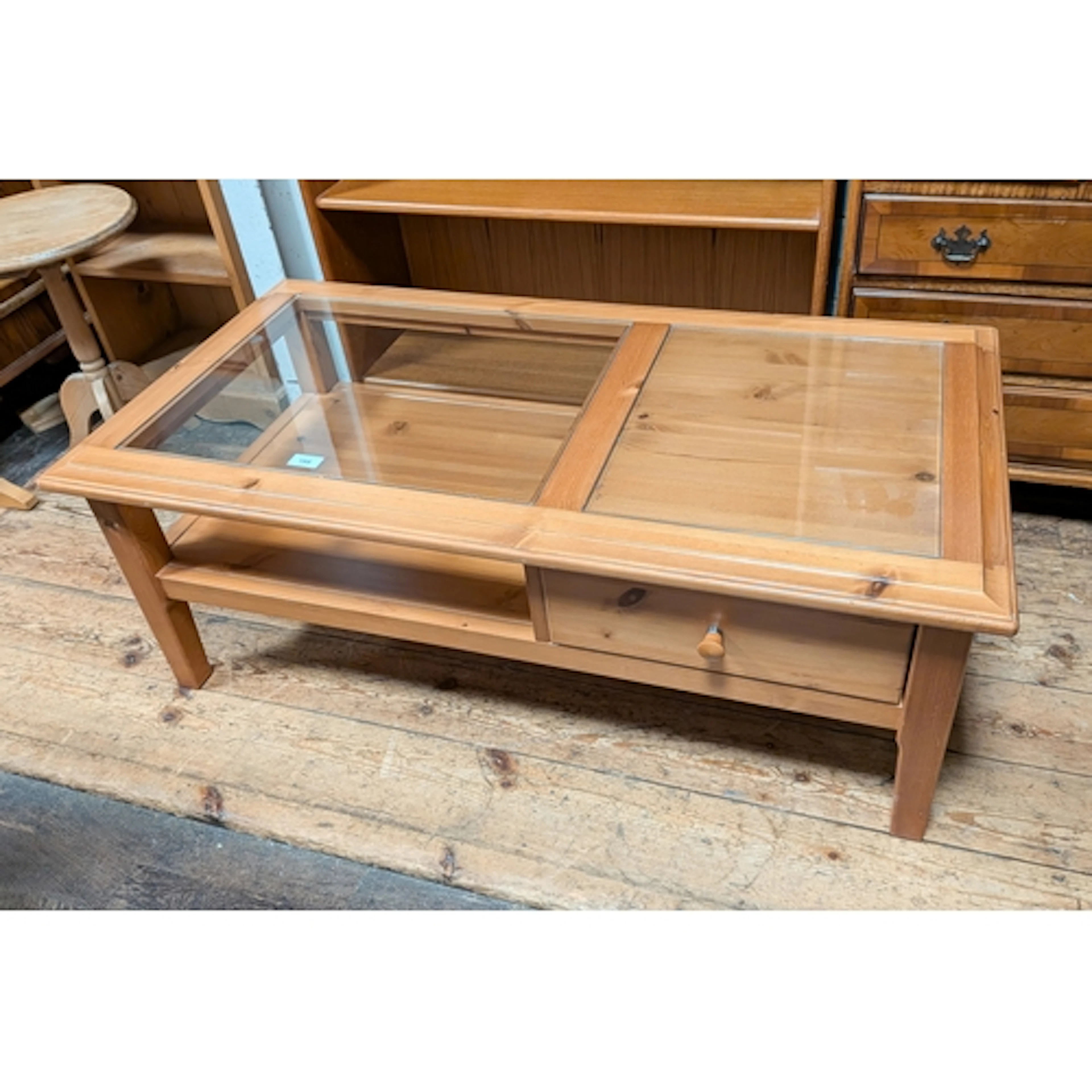 A modern pine storage style coffee table with inset glass to...