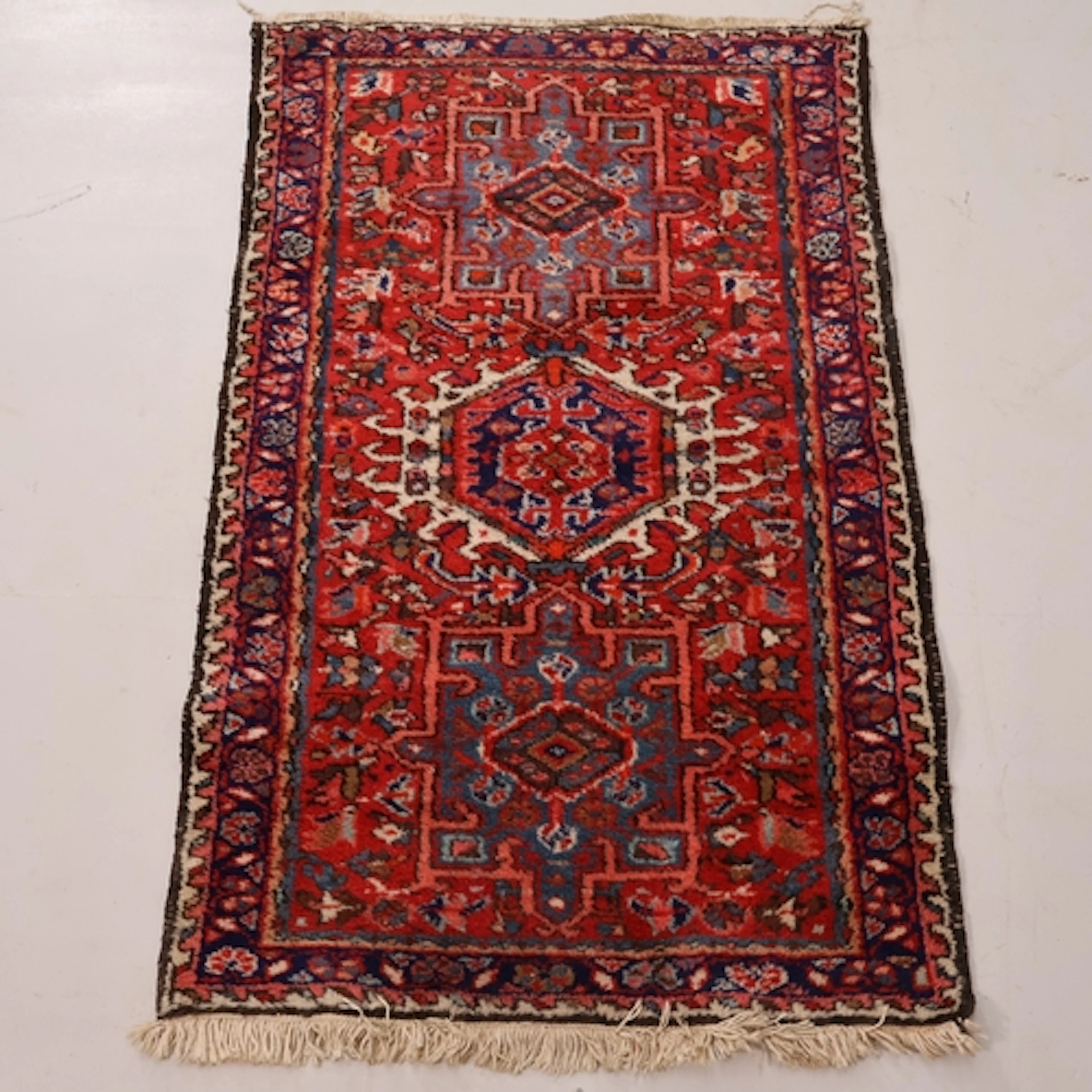A red-ground Heriz rug. L118cm, W76cm.
