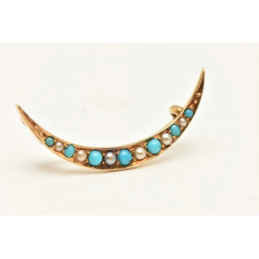 AN EARLY 20TH CENTURY BROOCH, a yellow metal crescent brooch...