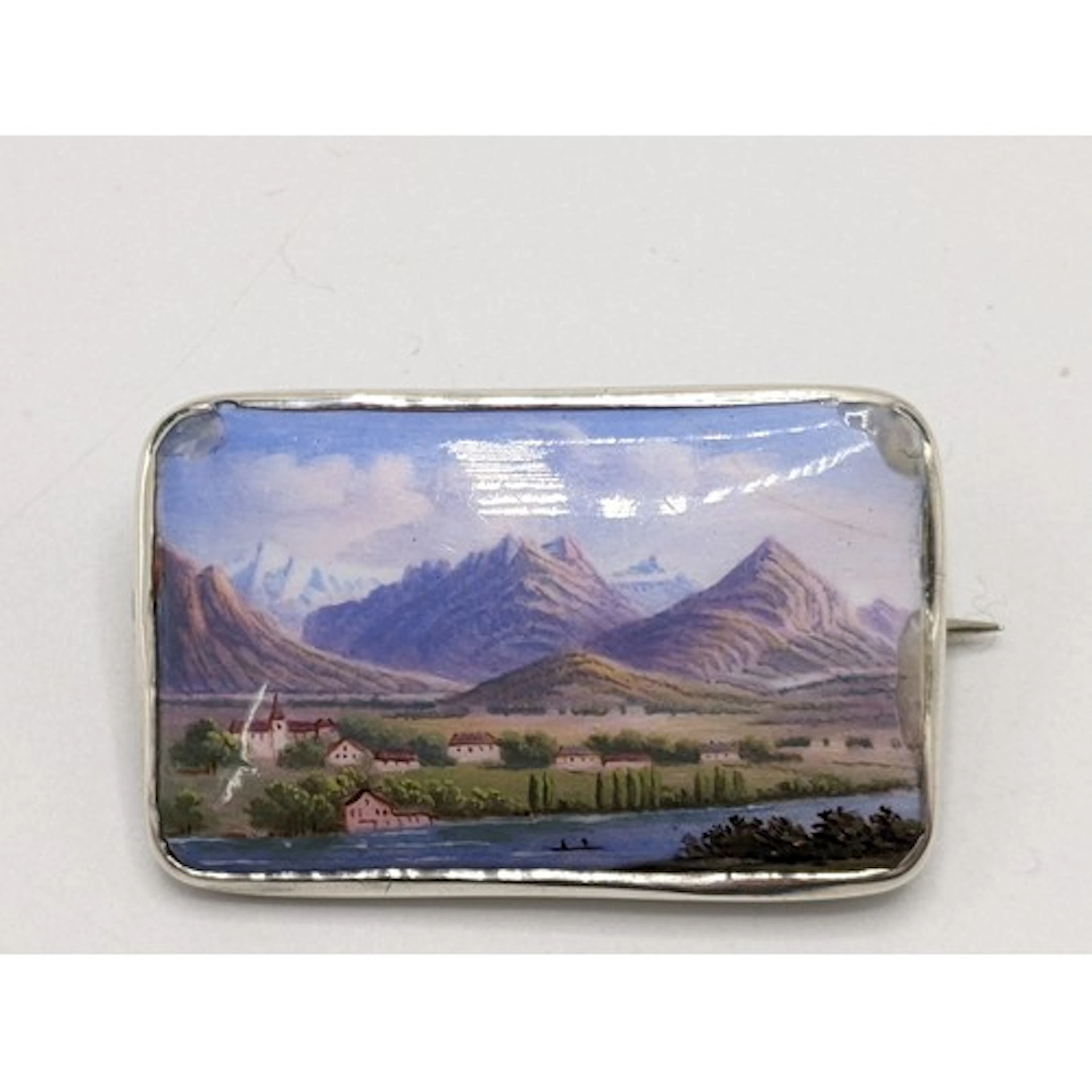 An early 20th century silver and enamelled brooch painted wi...