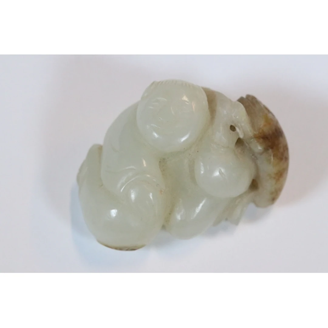 Jade carving, modelled as a man holding a large fish on his ...