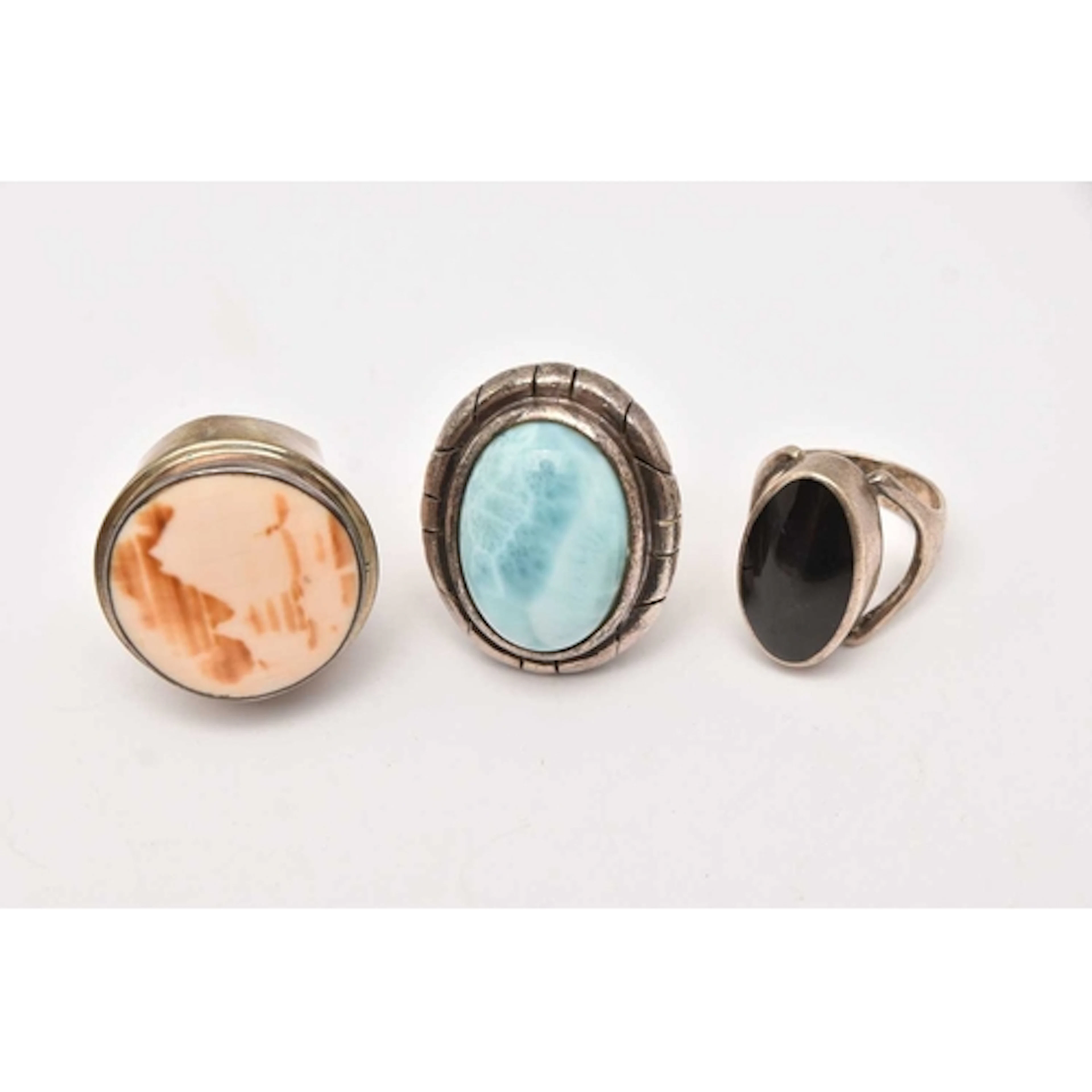 THREE WHITE METAL STATEMENT RINGS, the first a silver onyx s...
