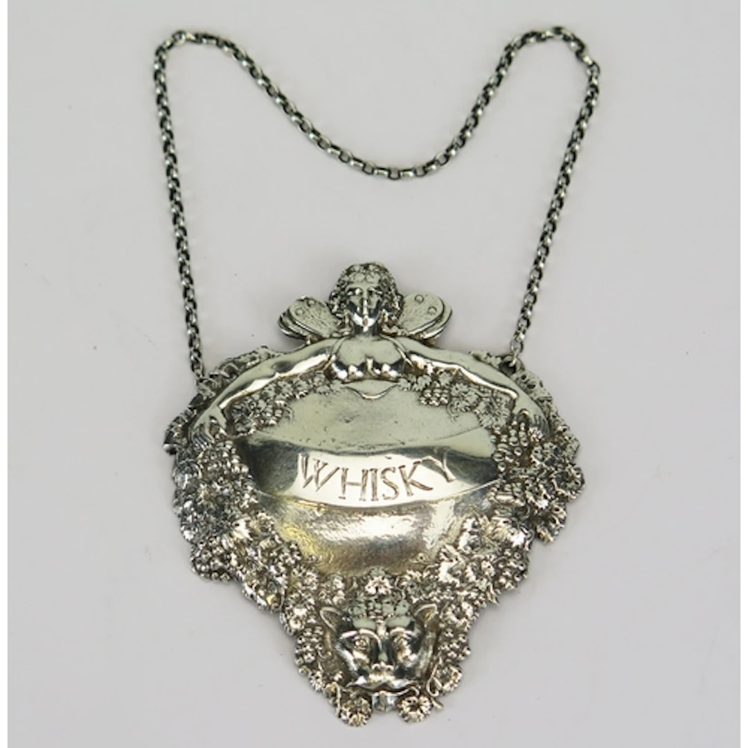 An Elizabeth II silver whisky decanter label with repousse d...