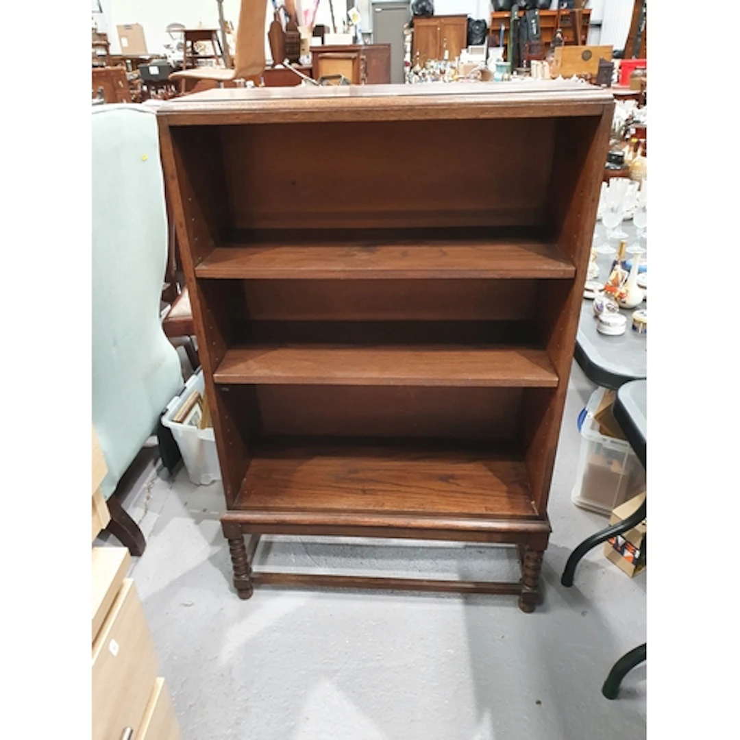 An oak open Bookcase fitted two adjustable shelves raised on...