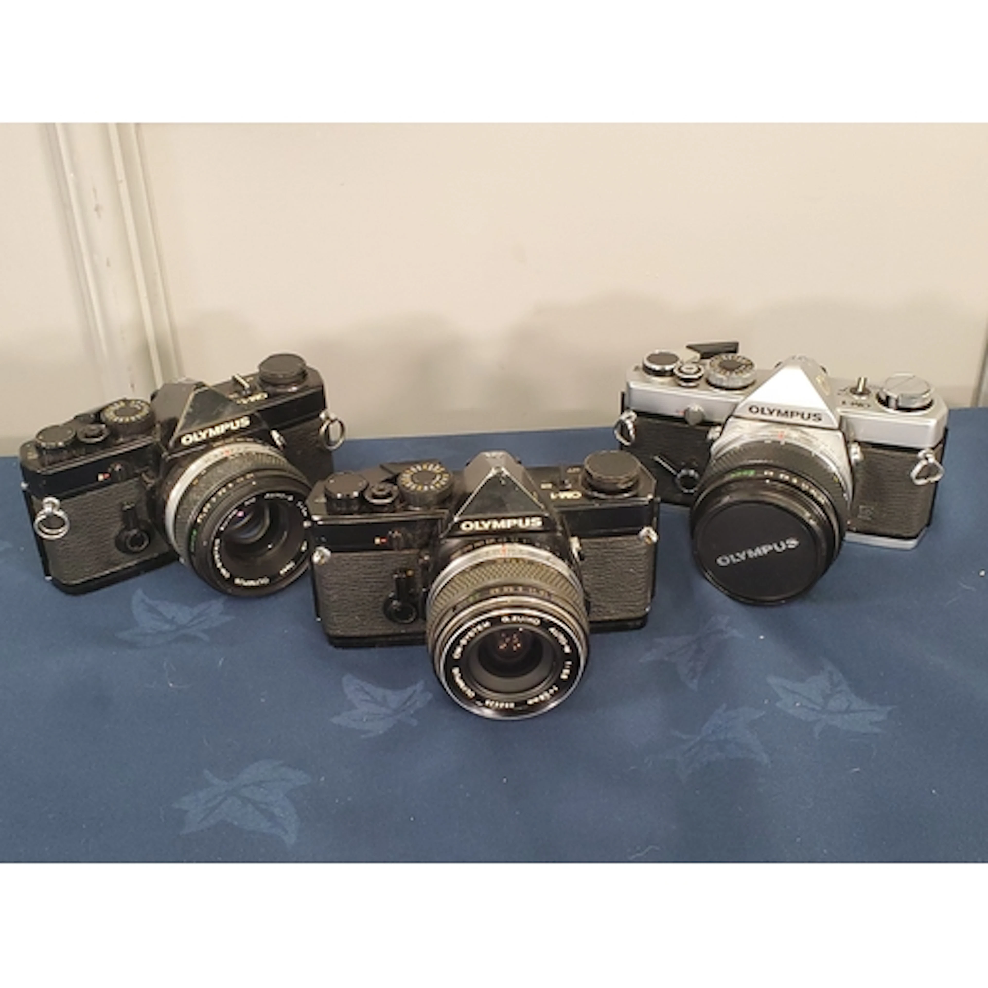 An Olympus OM-1 black with 28mm f3.5 Zuiko, rubbed, an Olymp...