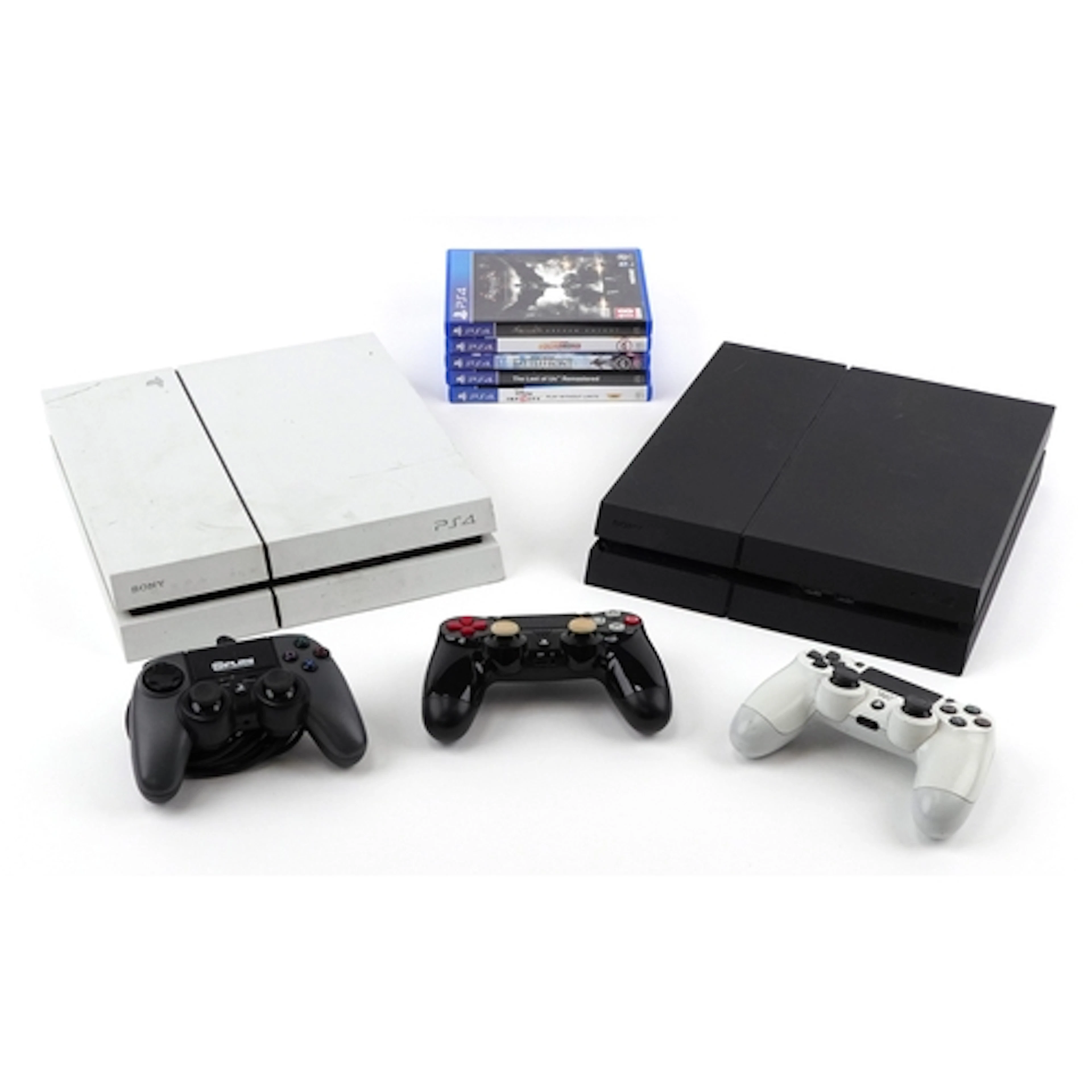 Two PlayStation PS4 games consoles with three controllers an...