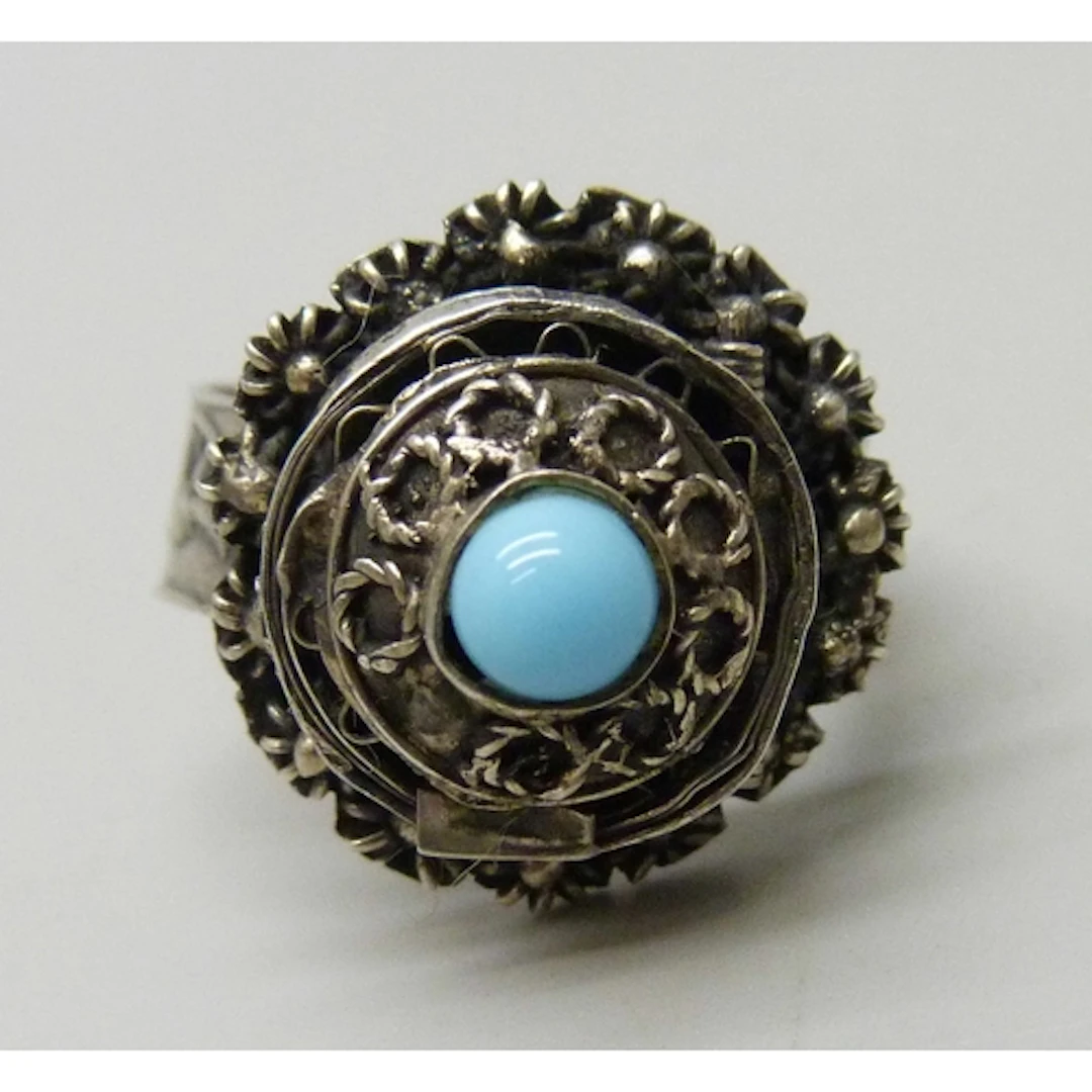 A white metal poison ring set with a cabochon blue stone, M/...