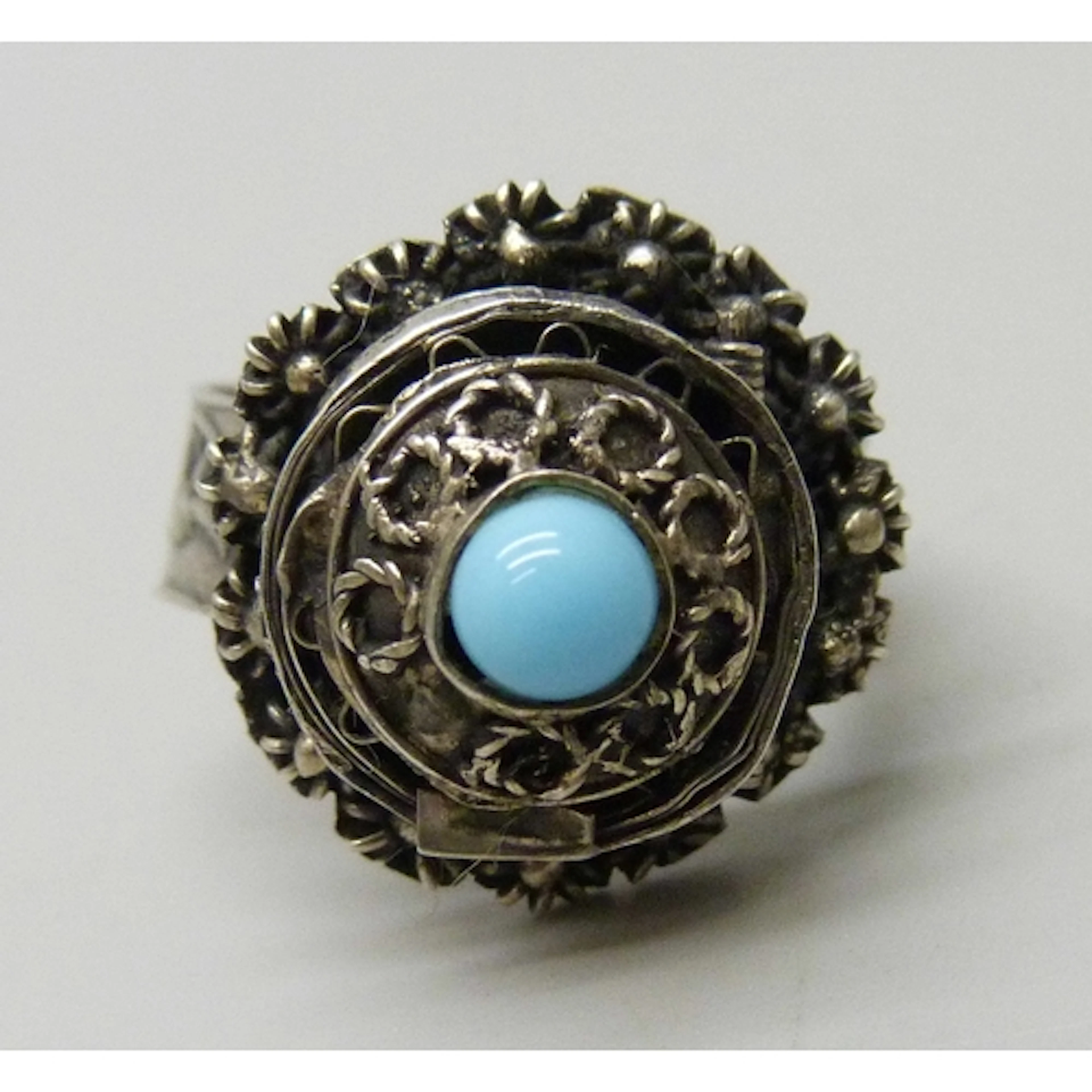 A white metal poison ring set with a cabochon blue stone, M/...