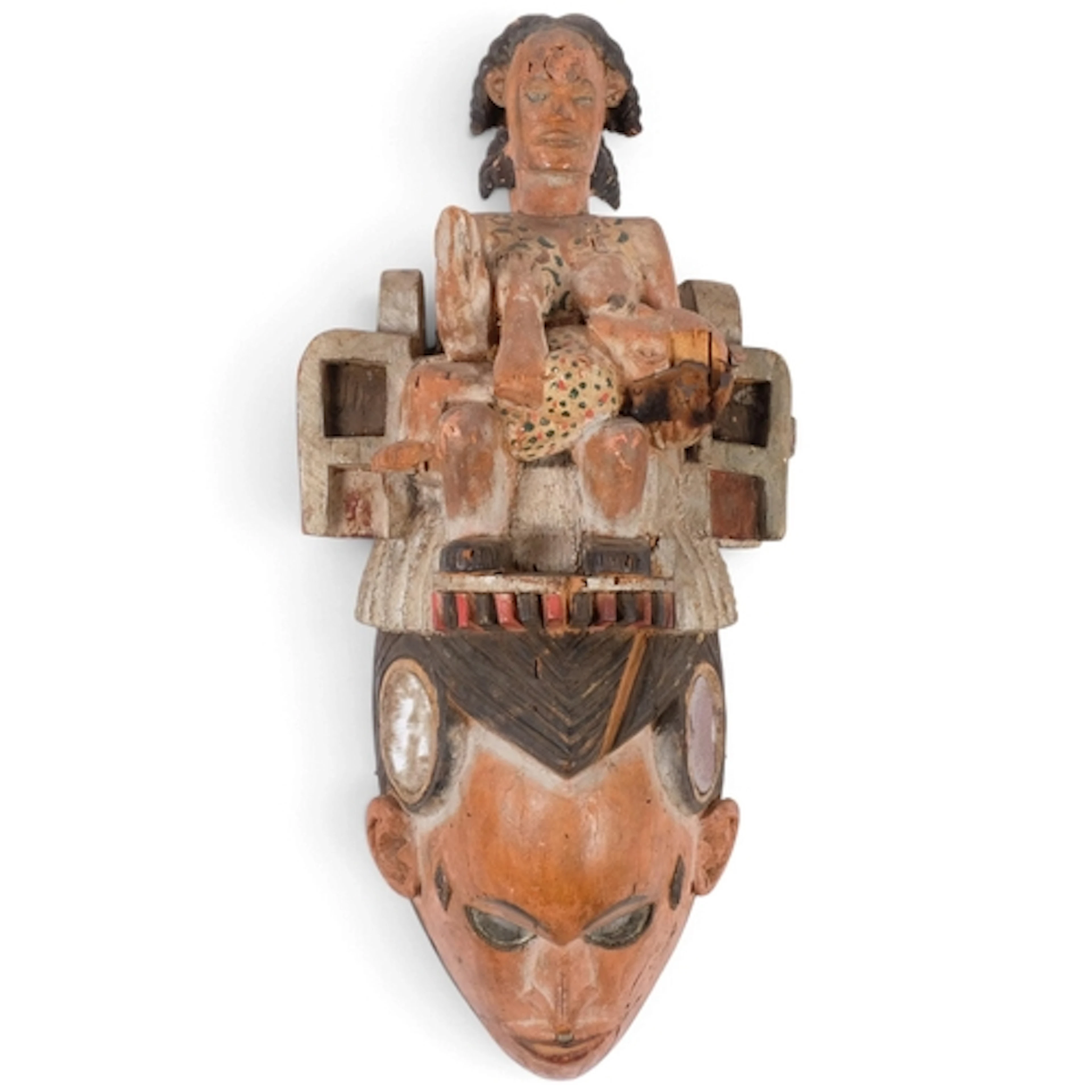 A Yoruba helmet mask, carved and painted wood, surmounted by...