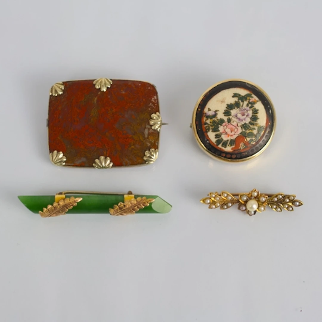 A group of four brooches, including a yellow metal mounted e...