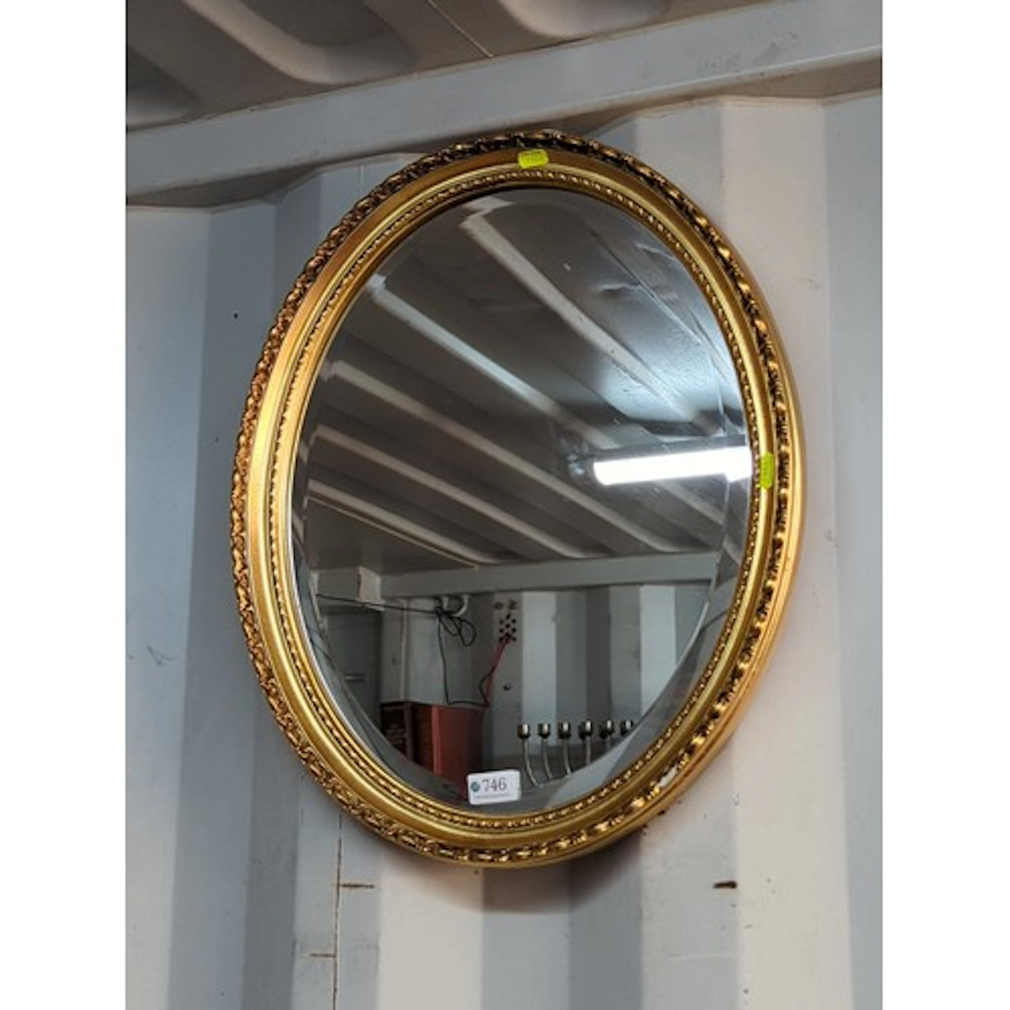 Oval gilt wall mirror with outer braided border and inner be...