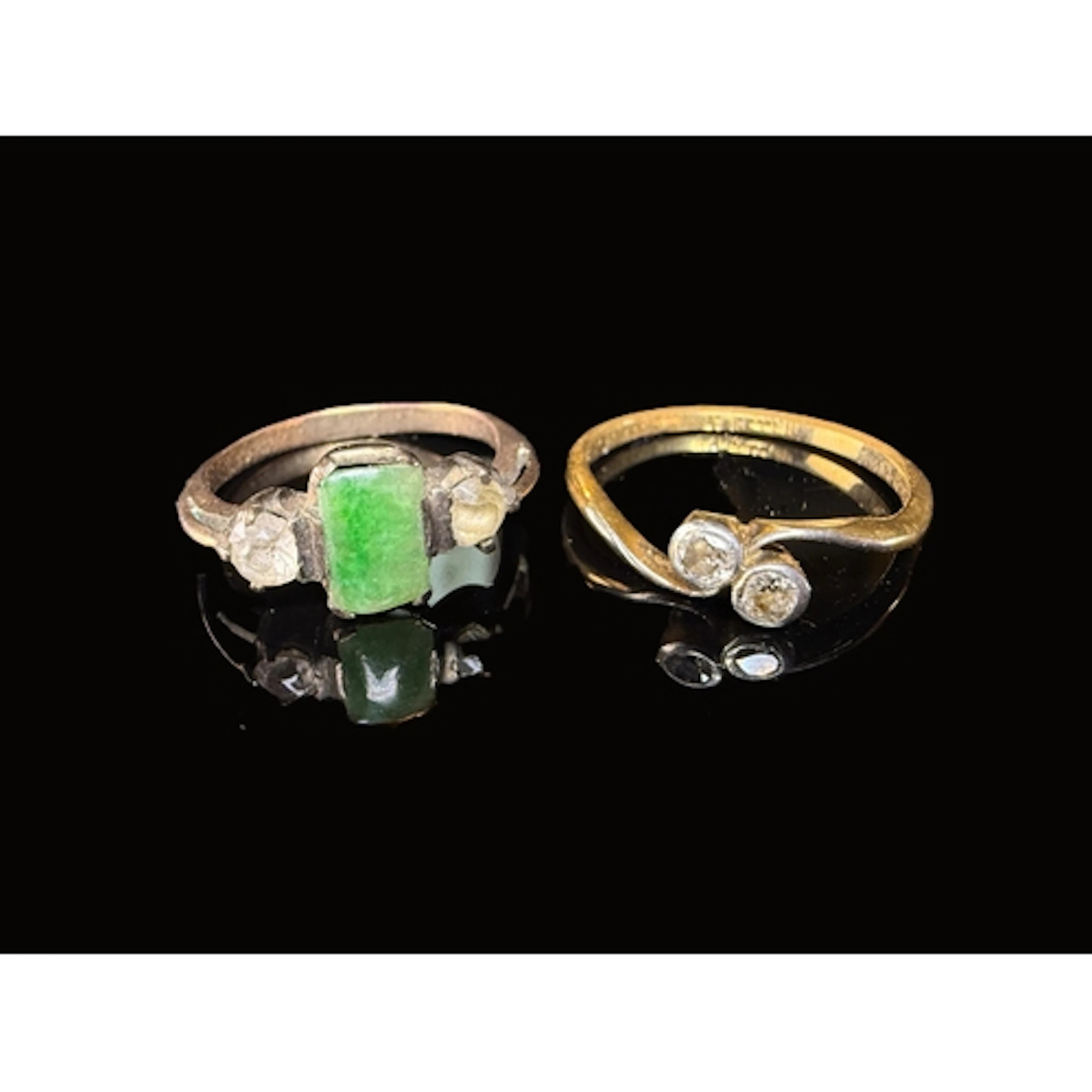 A yellow metal cross over engagement ring set with two diamo...