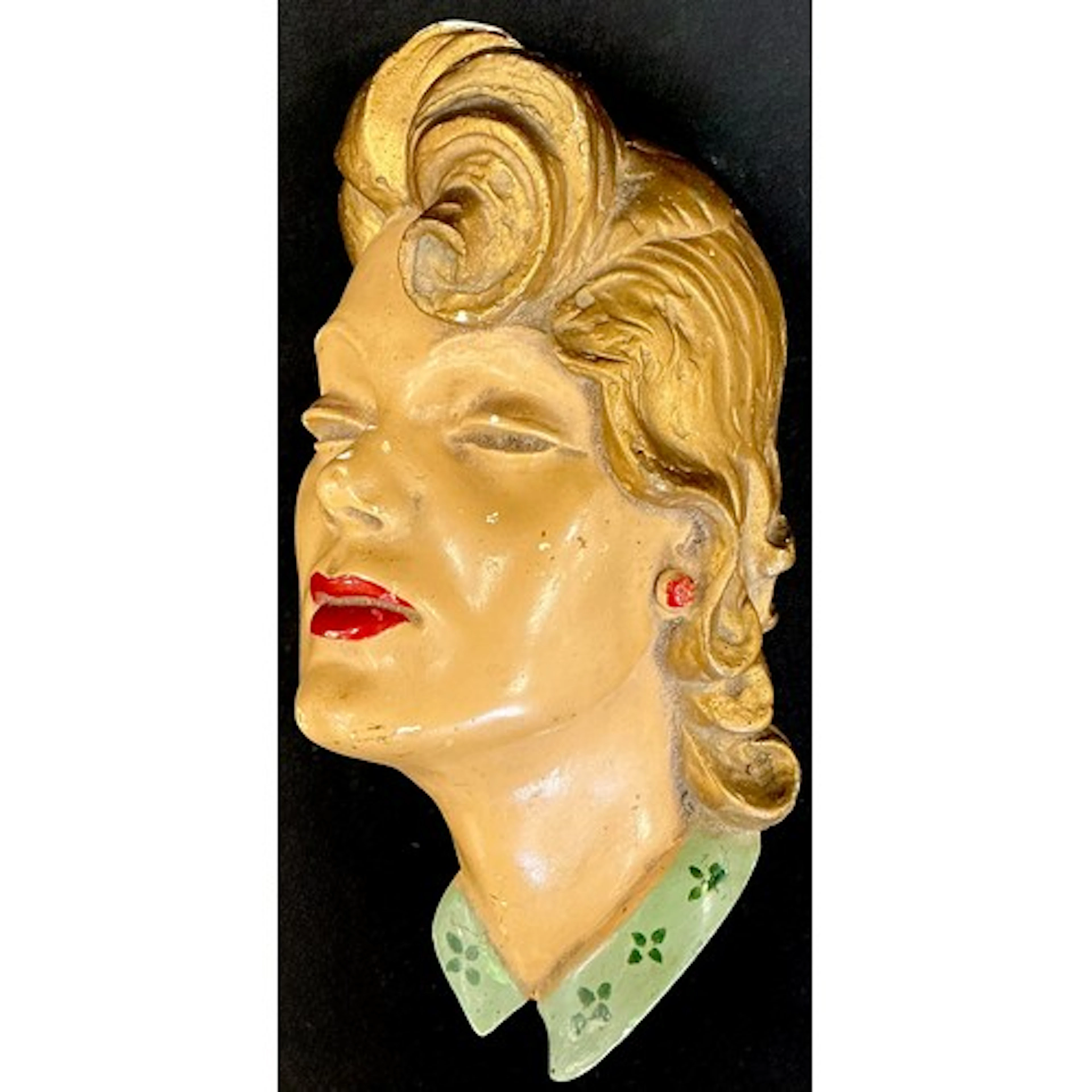 A Mid-Century cast plaster female face wall plaque in the ar...