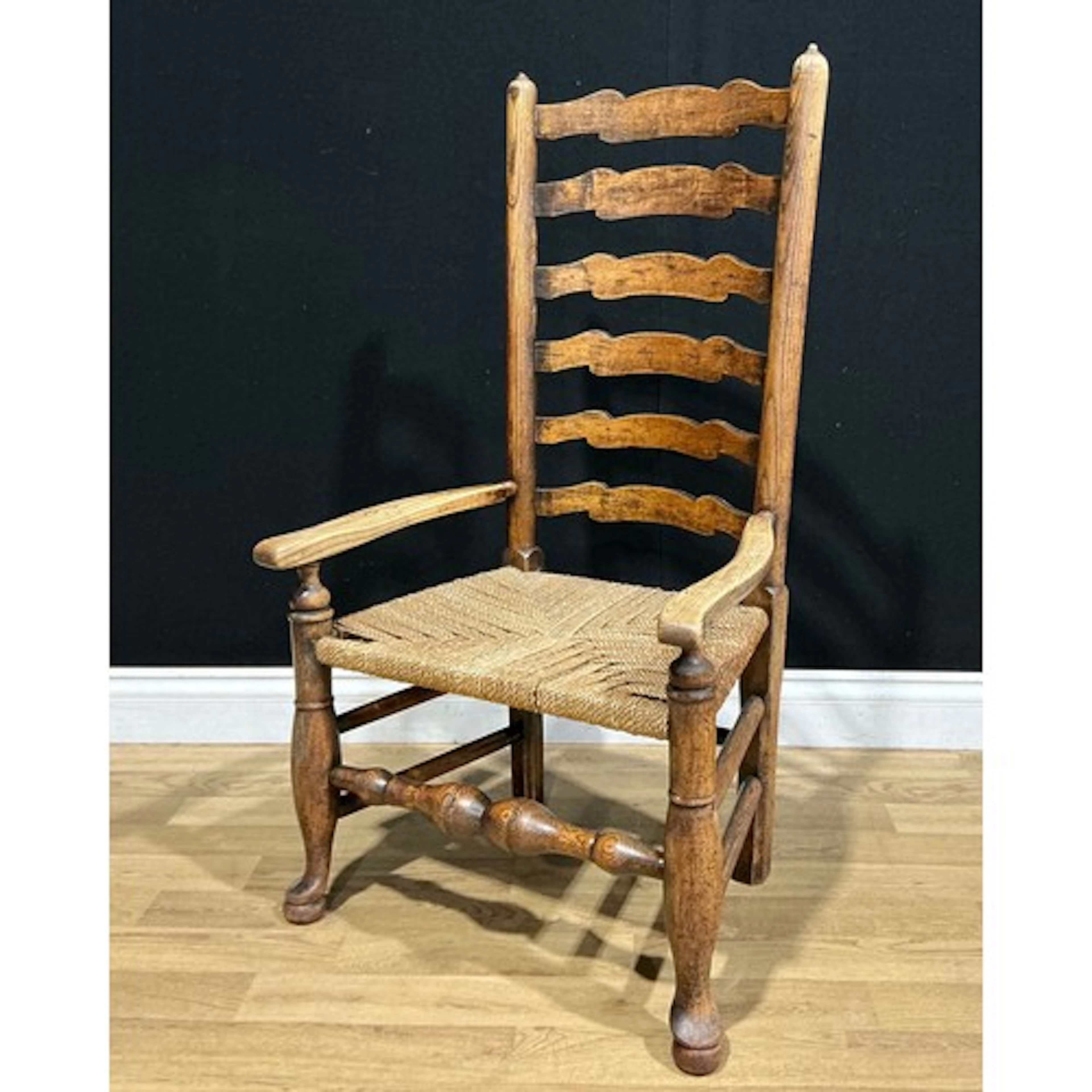 A 19th century Lancashire ash ladderback elbow chair, rope s...