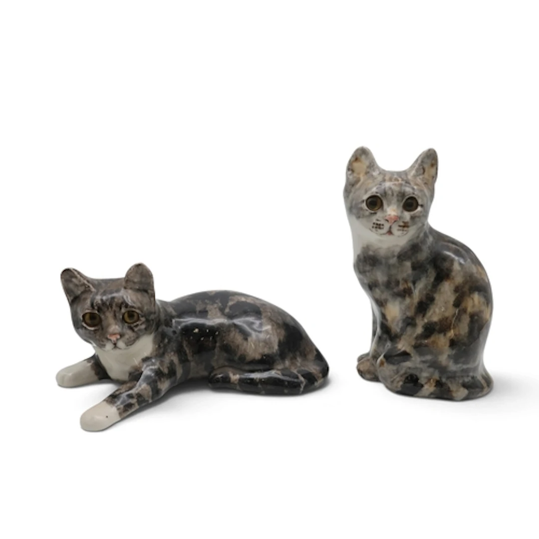 Two Winstanley cats with glass eyes, one sitting and the oth...