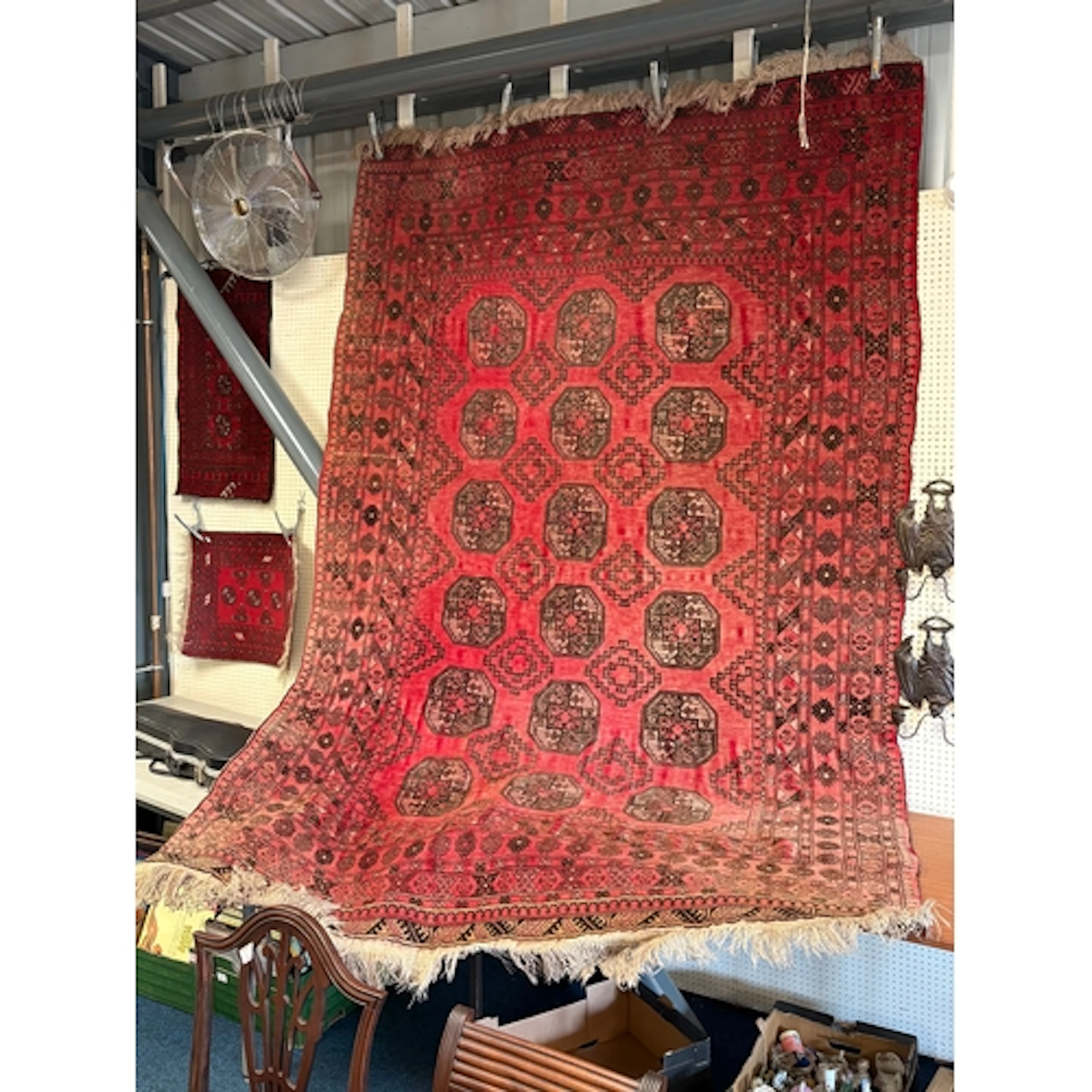 A large red ground Afghan Turkoman style rug which features ...