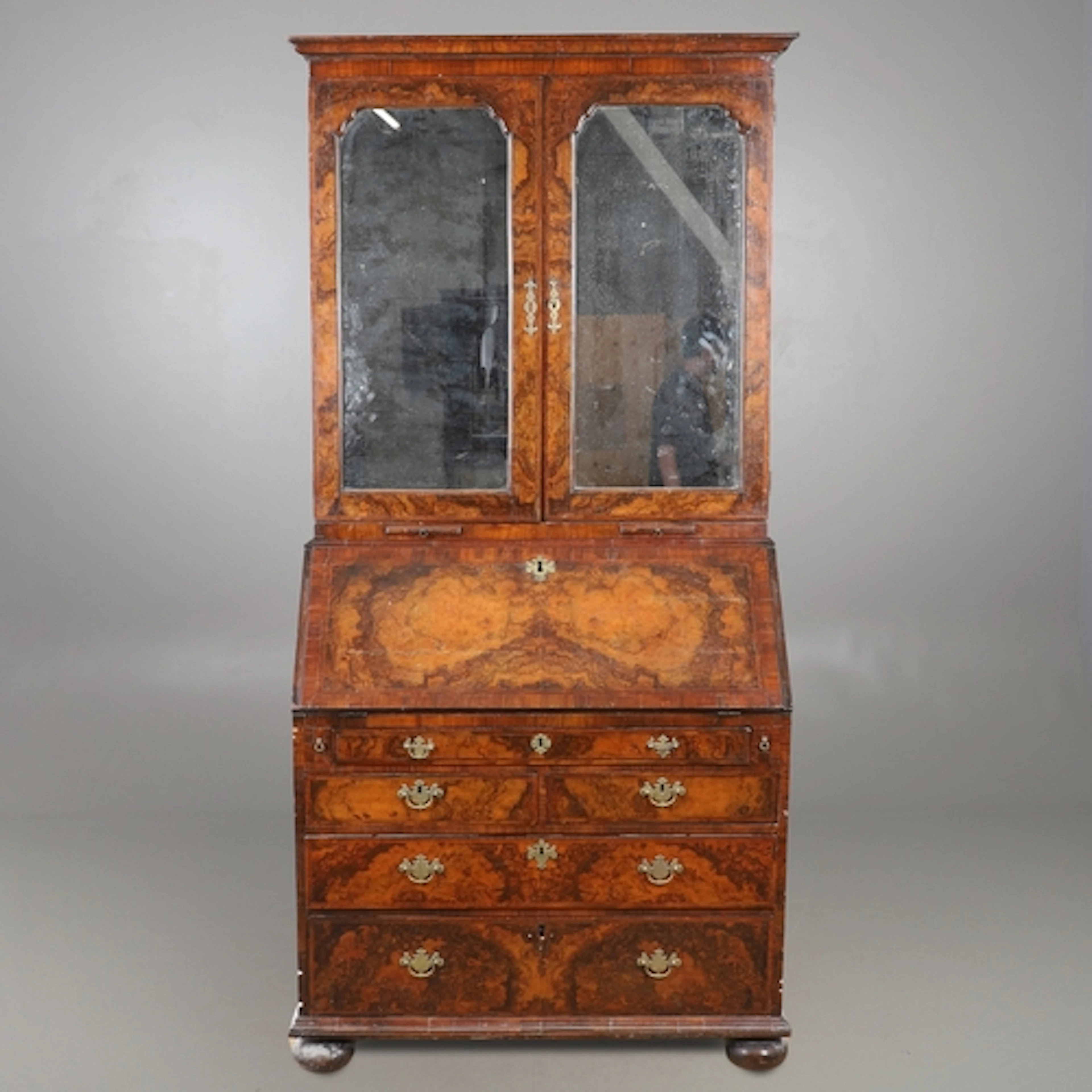 A GEORGE I BURR WALNUT & FEATHERBANDED BUREAU BOOKCASE. the ...