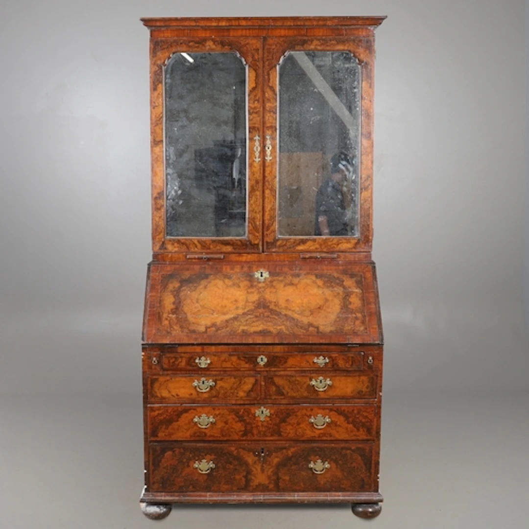 A GEORGE I BURR WALNUT & FEATHERBANDED BUREAU BOOKCASE. the ...