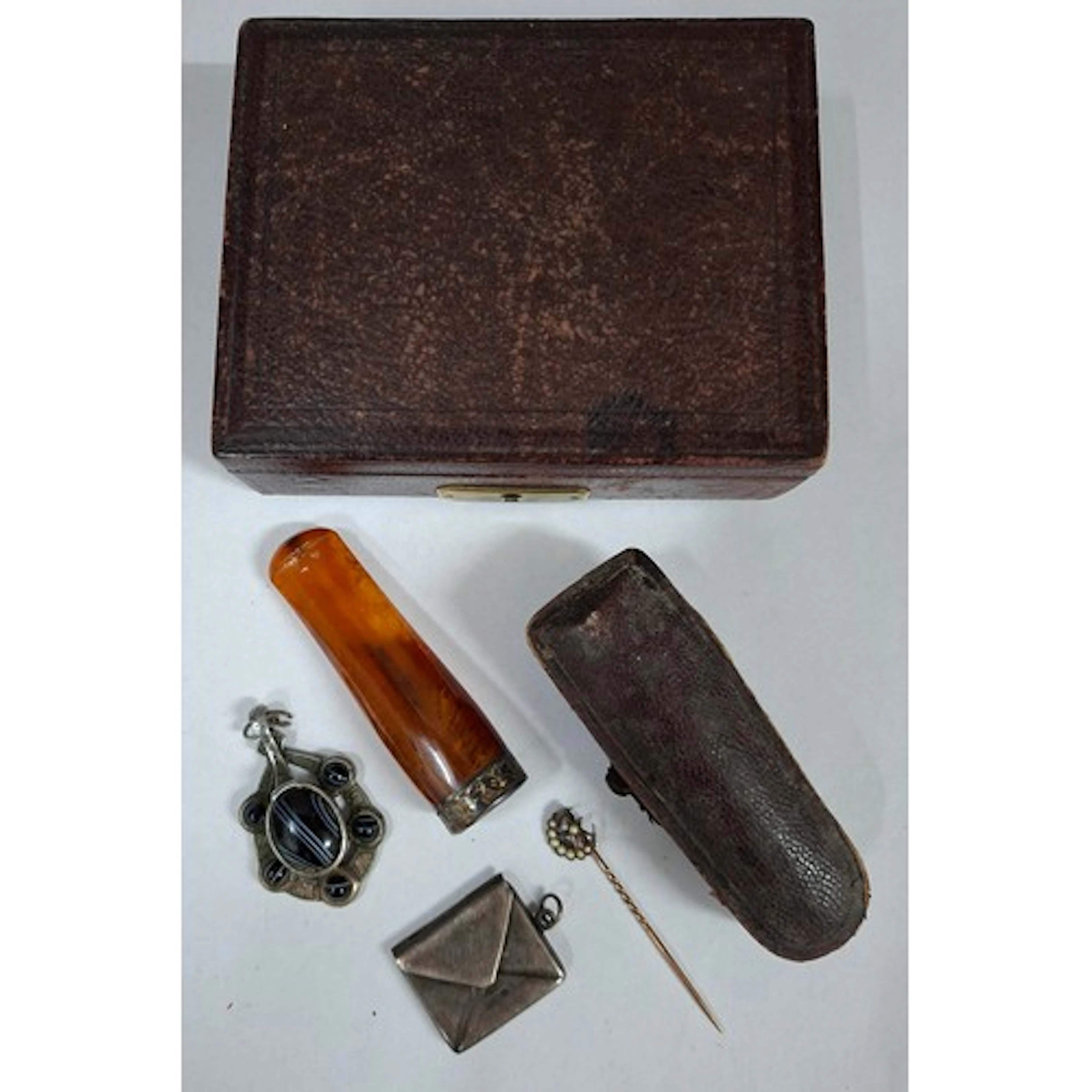 An early 20th Century small burgundy leather box, an amber c...