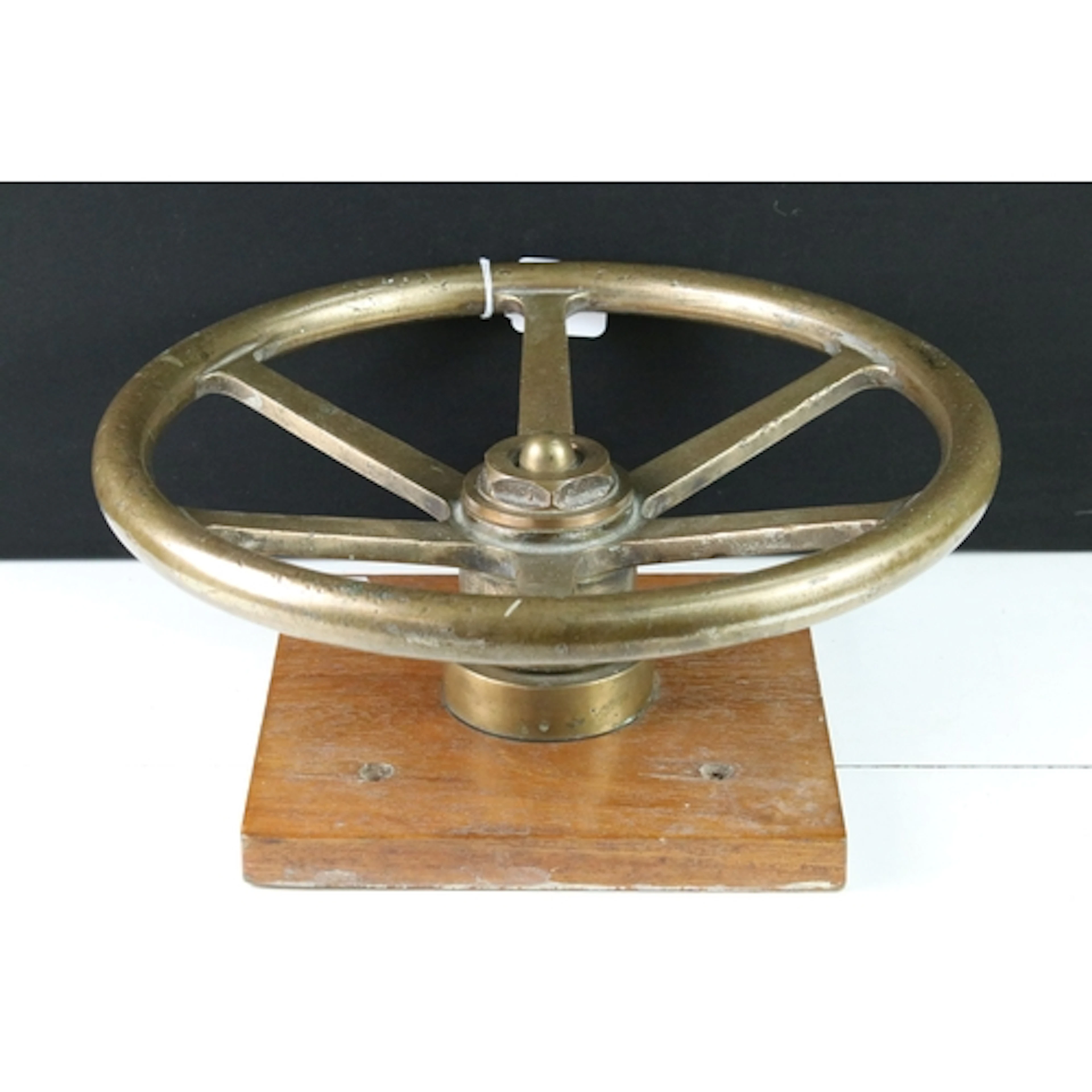 20th century cast brass steering wheel, mounted on wooden pl...