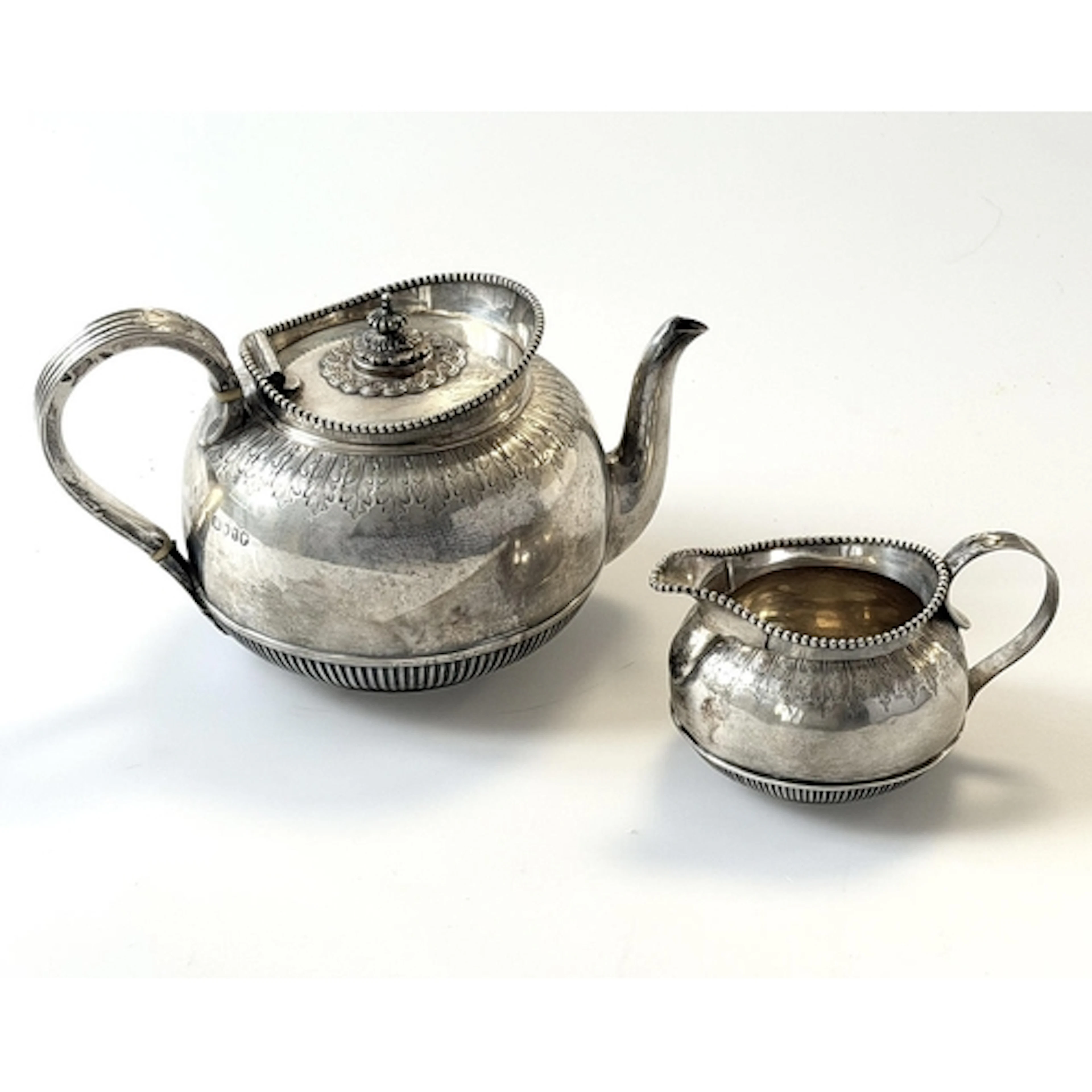 A VICTORIAN GREEK REVIVAL SILVER TEAPOT AND CREAM JUG. of sp...