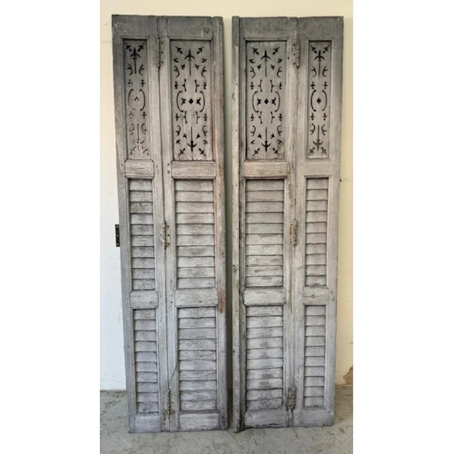 A pair of vintage French shutters with pierced and slatted p...