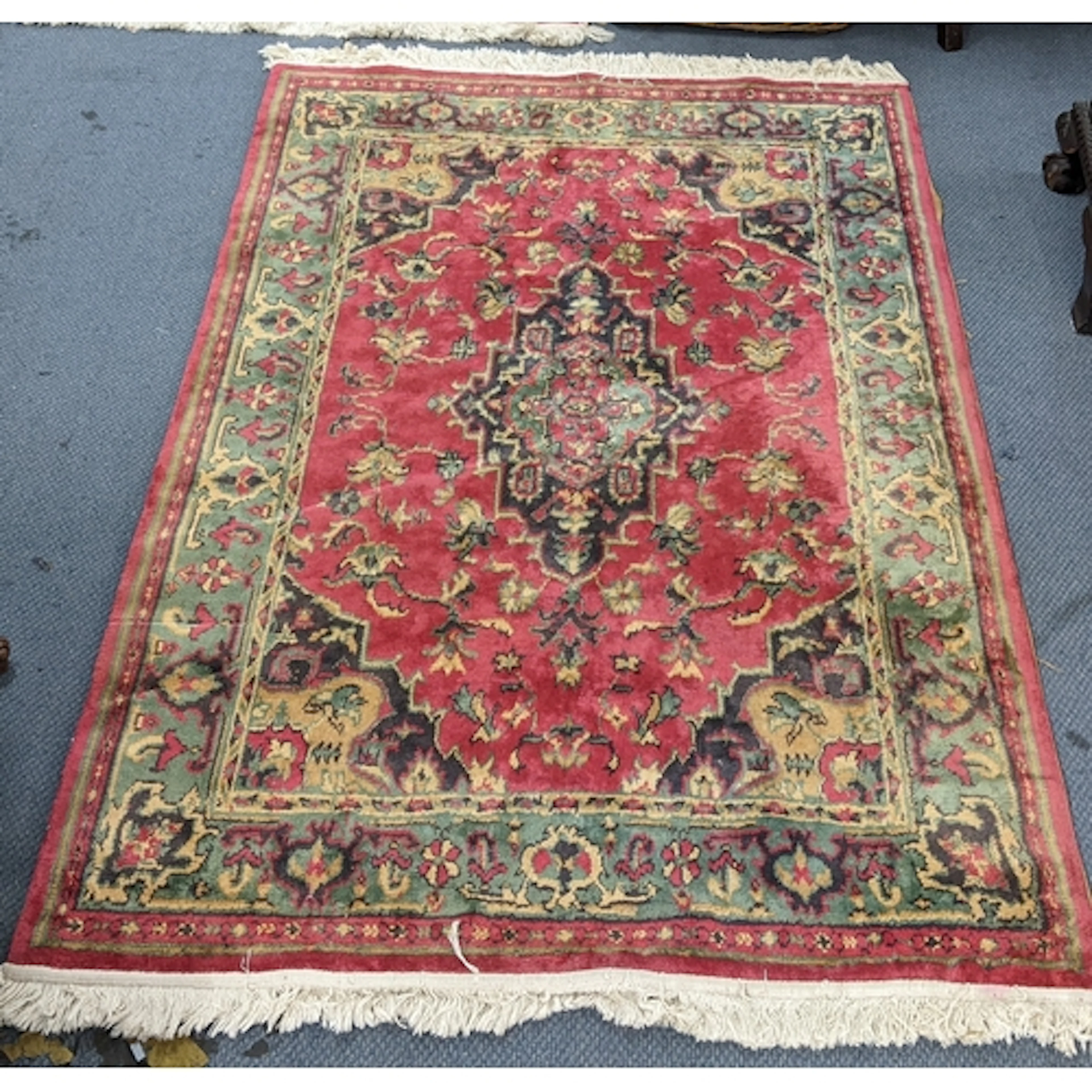A pair of Chinese red ground rugs, each having a central mot...