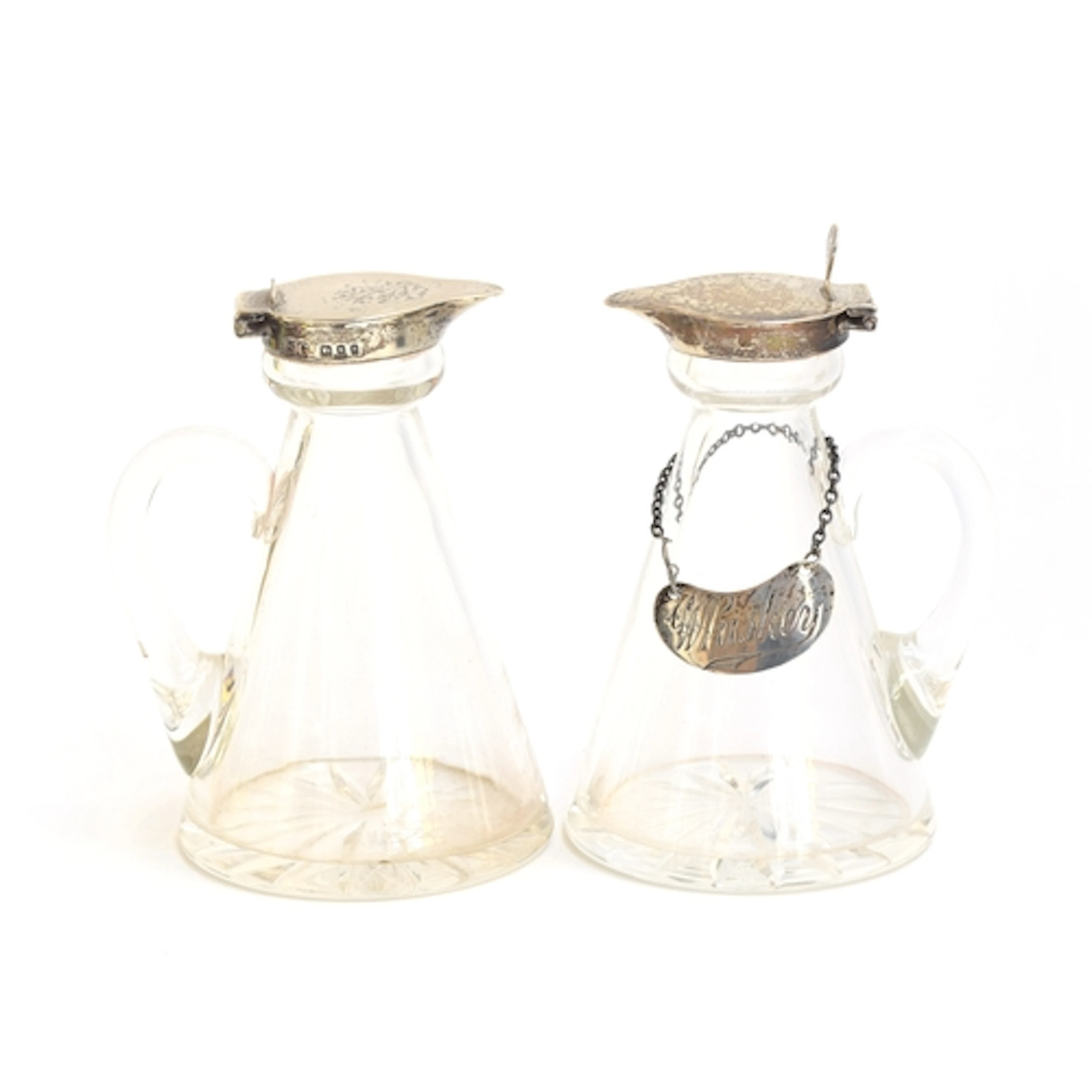 A pair of silver topped glass whiskey noggins, by Garrard & ...