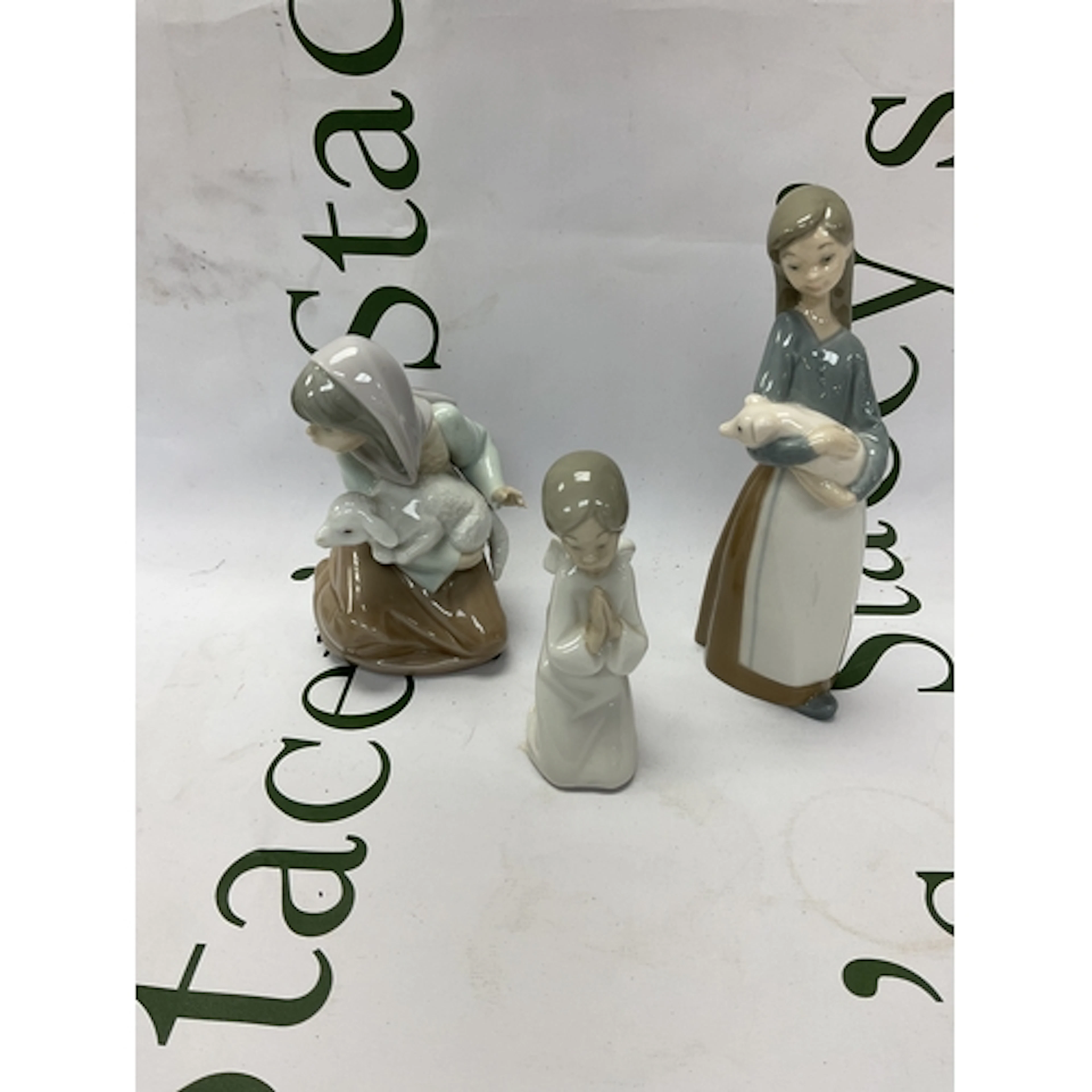 Two Lladro figures and a NAO angel.