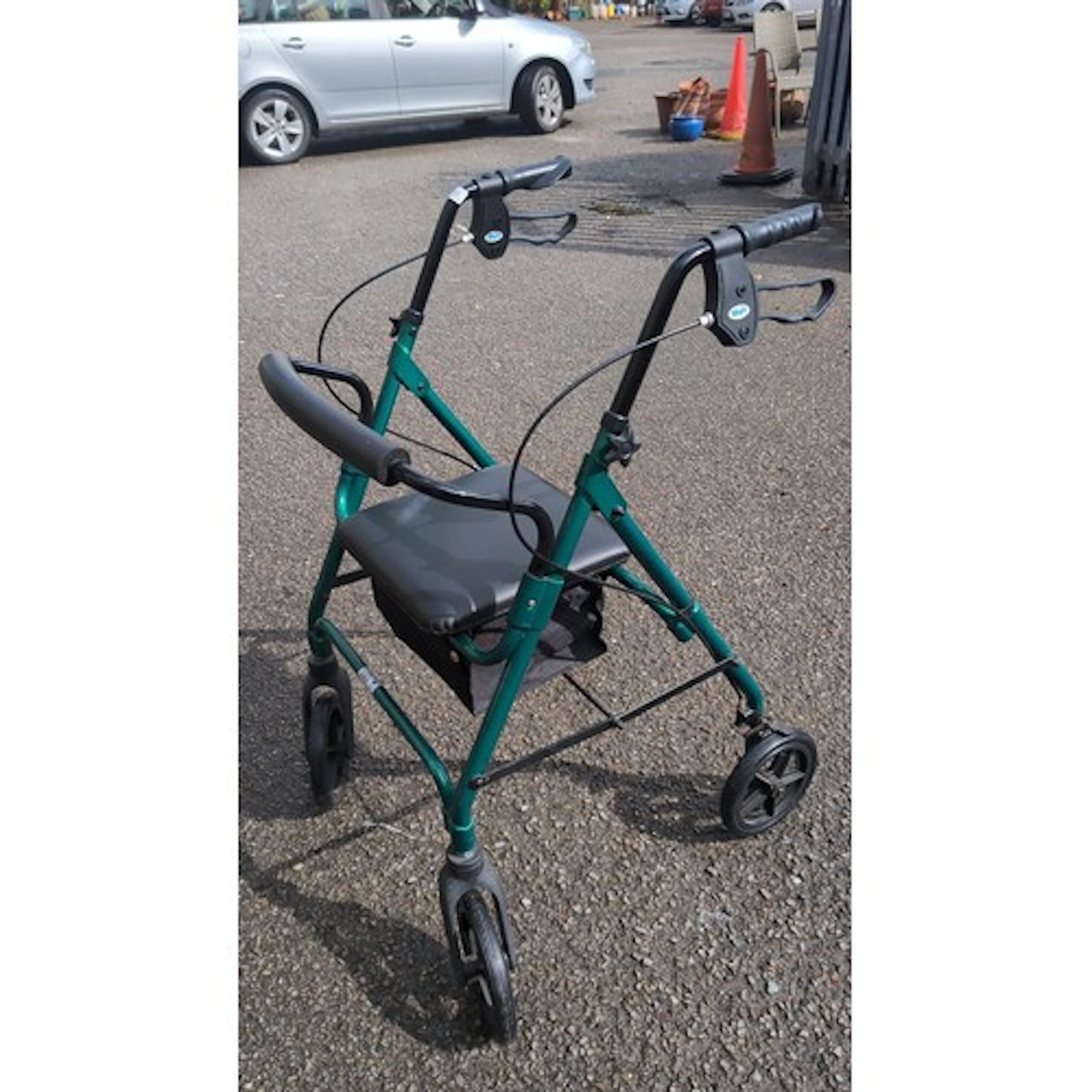 Folding mobility rollator in green-painted tubular metal.