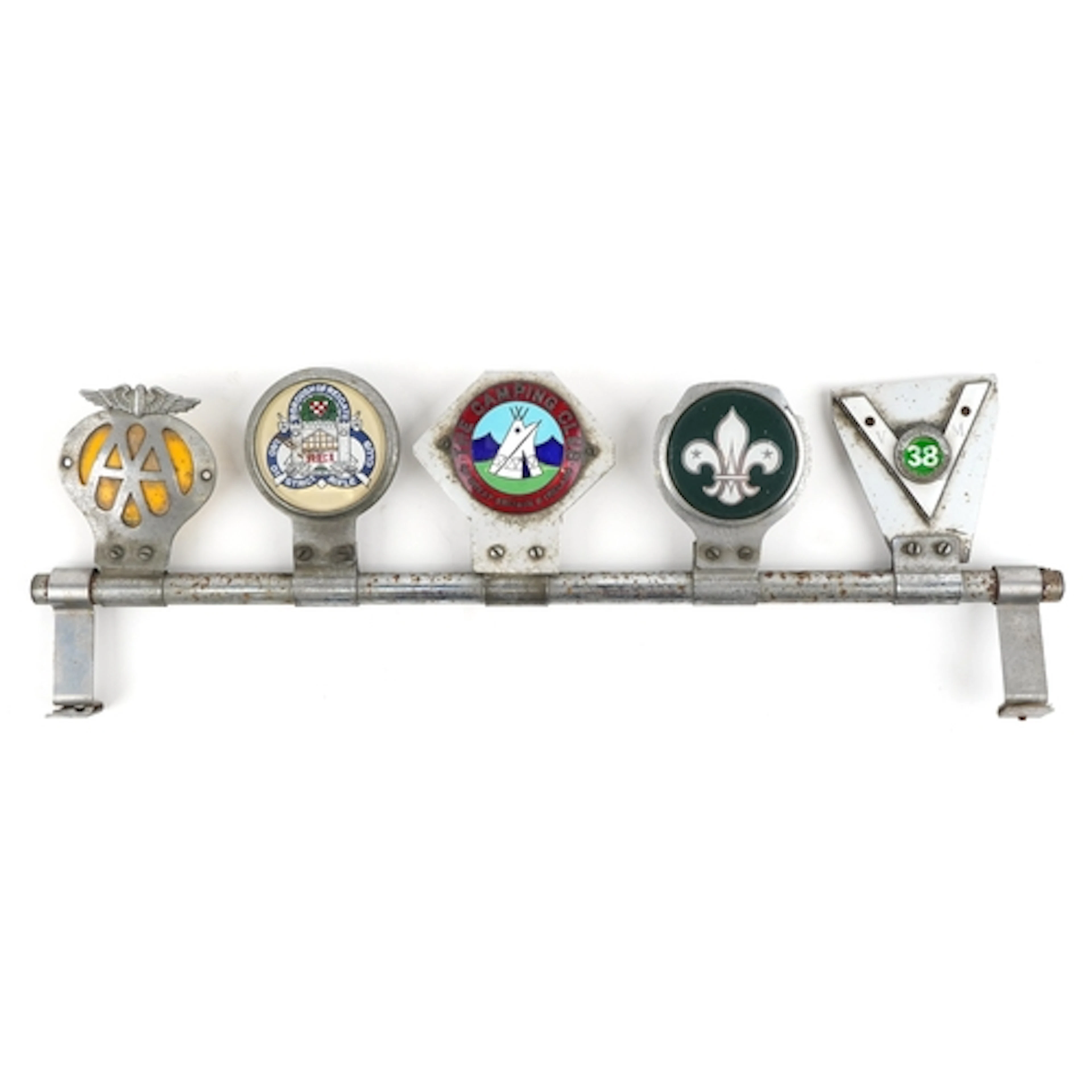 Five vintage car radiator badges mounted on a bar, including...