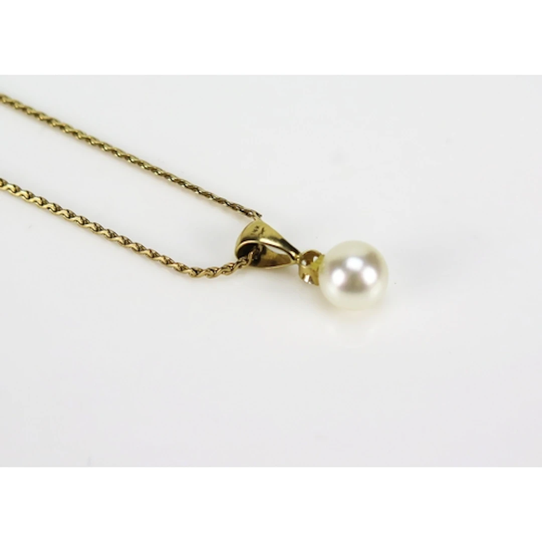 A cultured pearl and diamond pendant in a 14K yellow gold se...