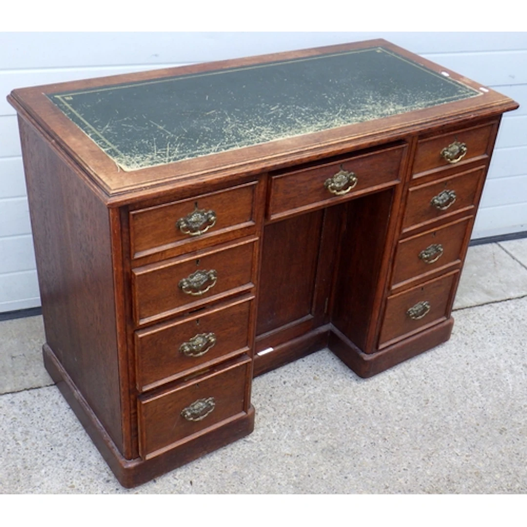 An Edwardian oak kneehole desk with green inset top, 114cm w...
