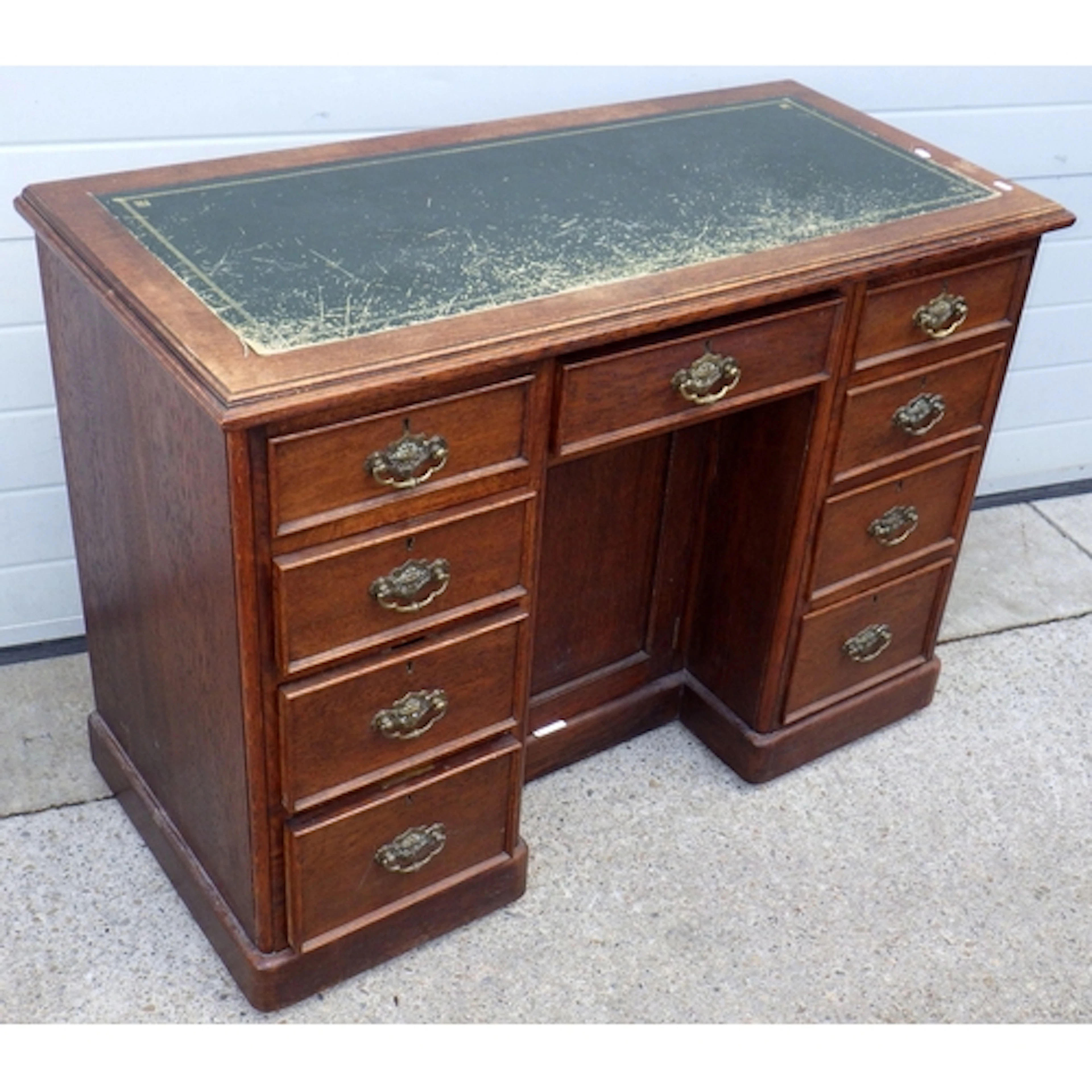 An Edwardian oak kneehole desk with green inset top, 114cm w...