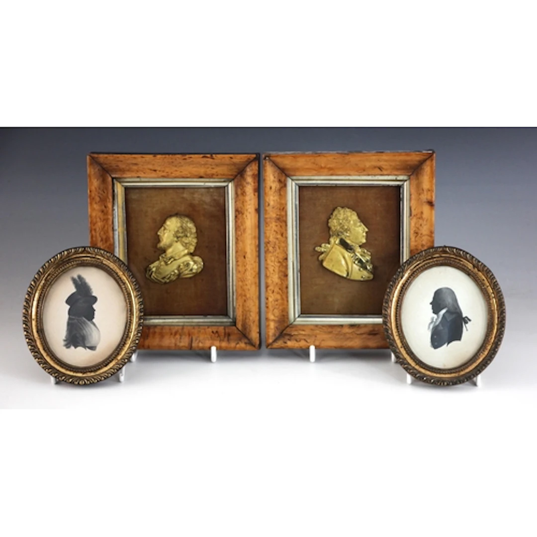 A pair of relief cast gilt metal portrait profile busts, one...