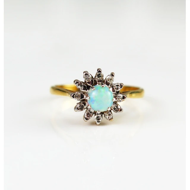 An opal and diamond cluster ring in an 18 carat yellow gold ...