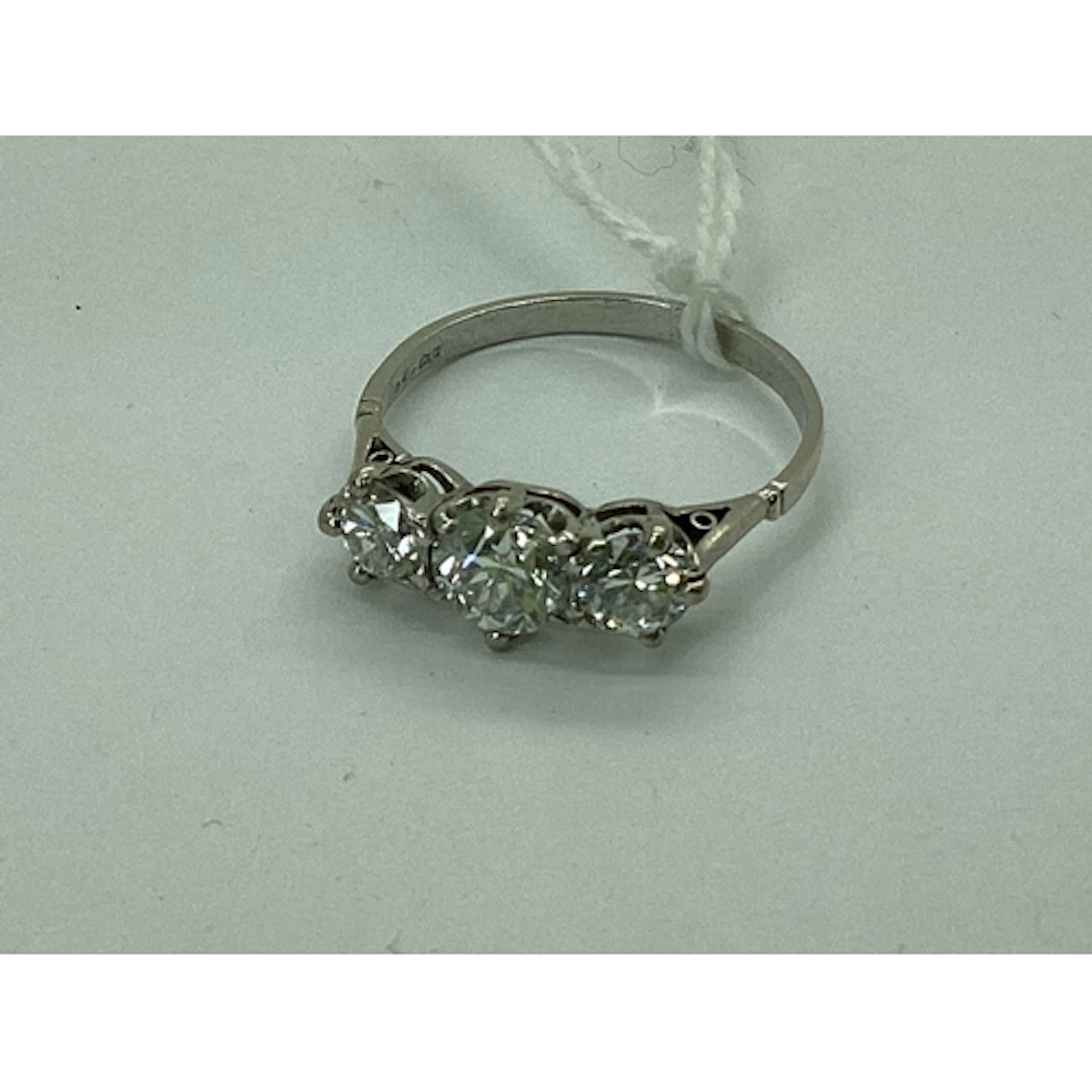 A Platinum Three Stone Diamond Ring, the graduated brilliant...