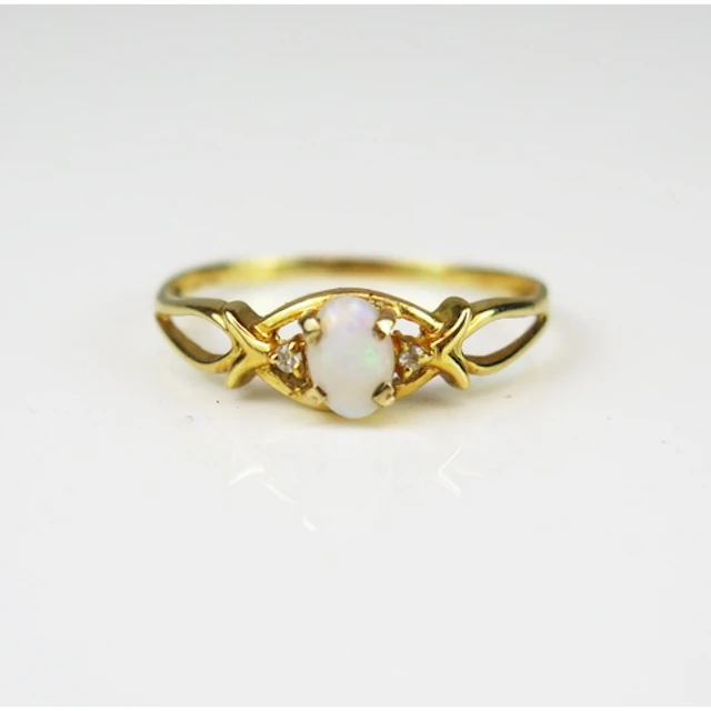 An opal and diamond three stone ring in an 18ct yellow gold ...