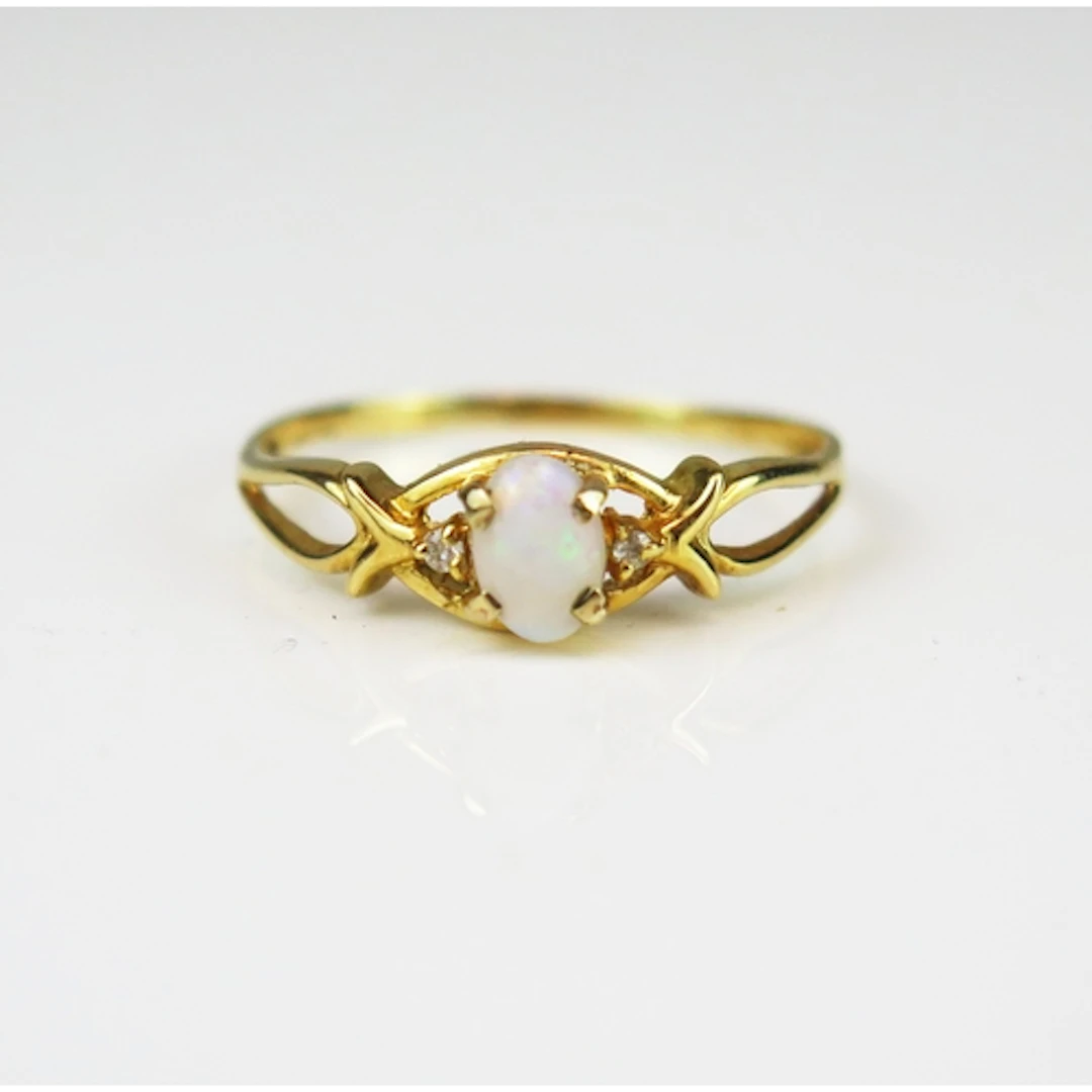 An opal and diamond three stone ring in an 18ct yellow gold ...