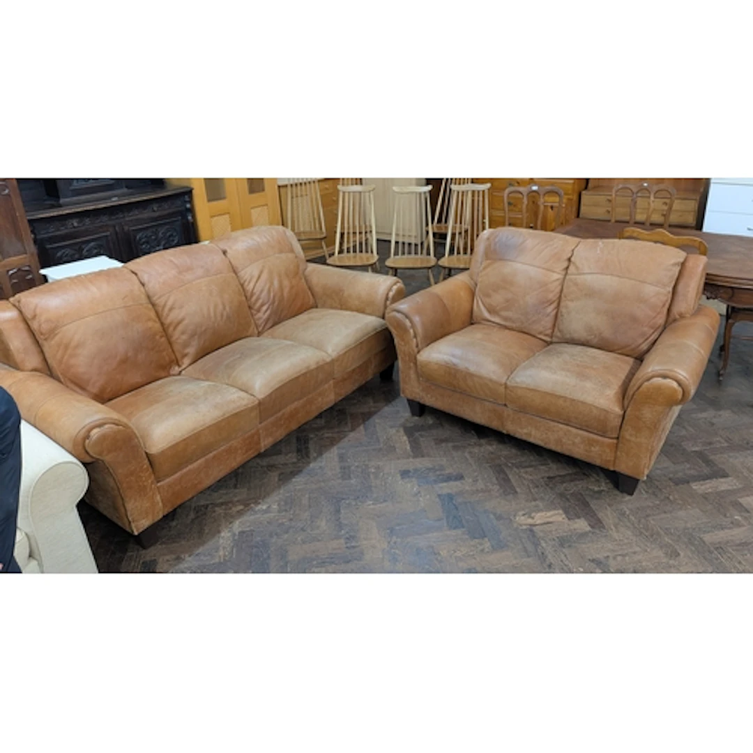A three seater settee in tan leather with studs to arms and ...