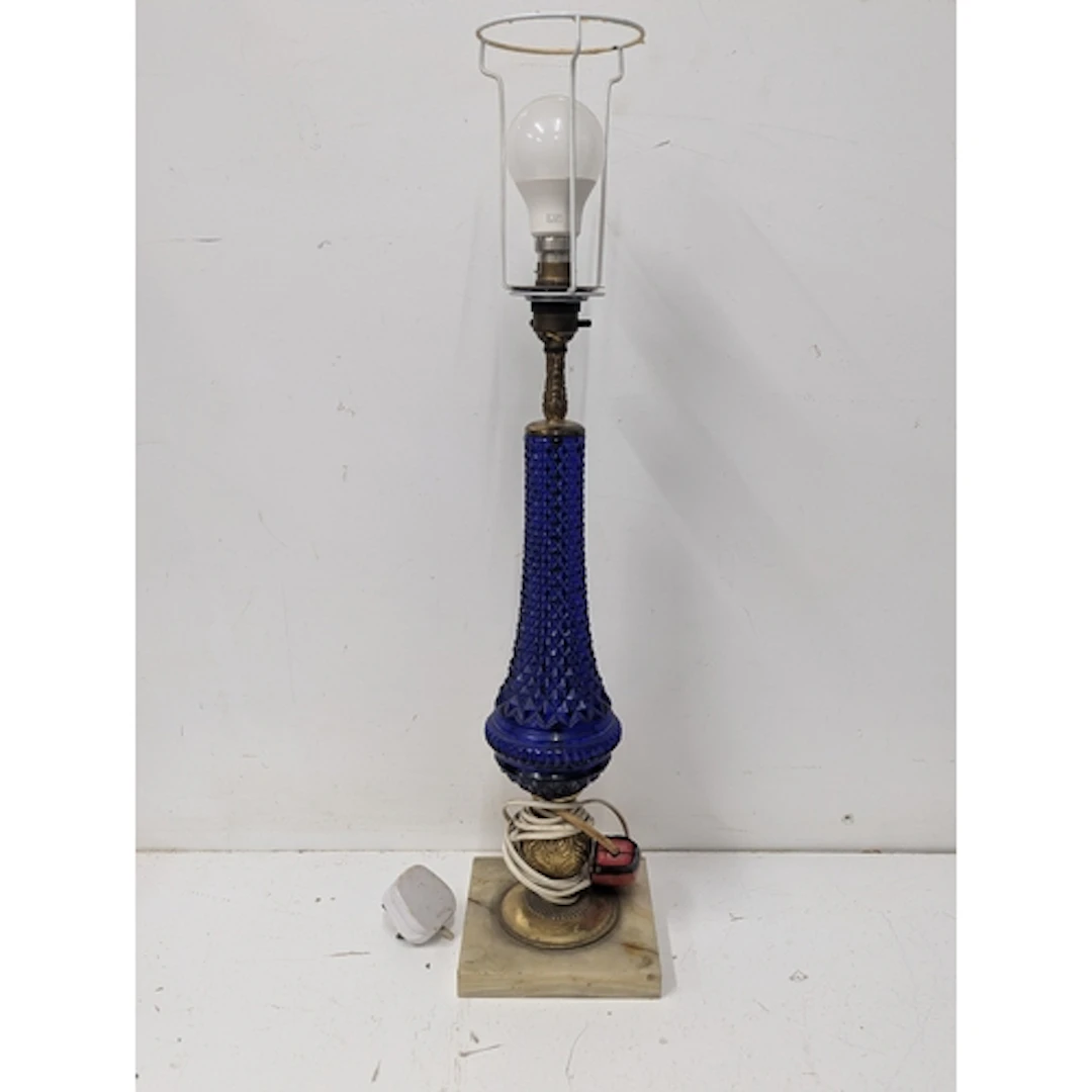 A table lamp featuring a diamond pattern cobalt blue glass b...