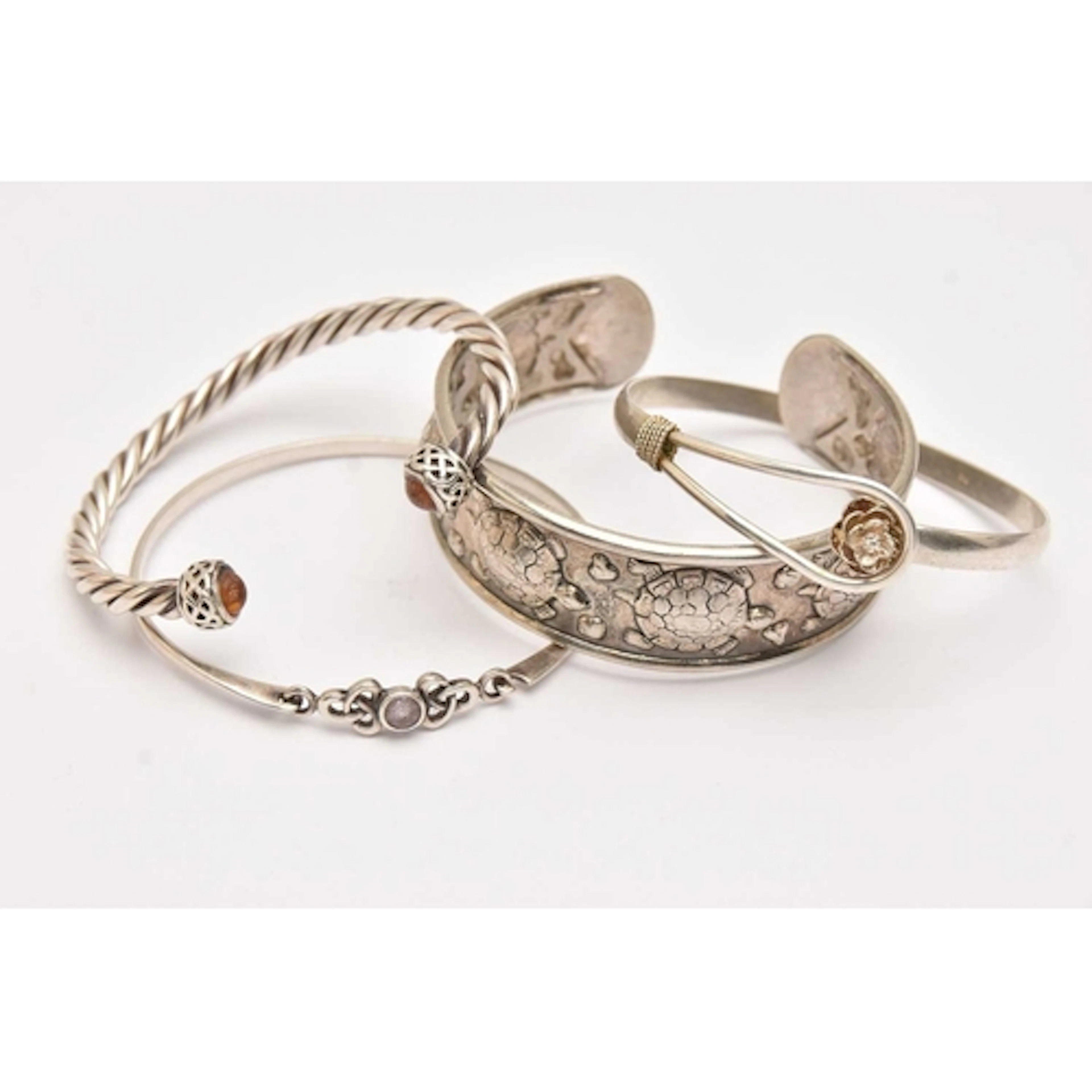 FOUR BANGLES, to include a silver twisted torque bangle with...