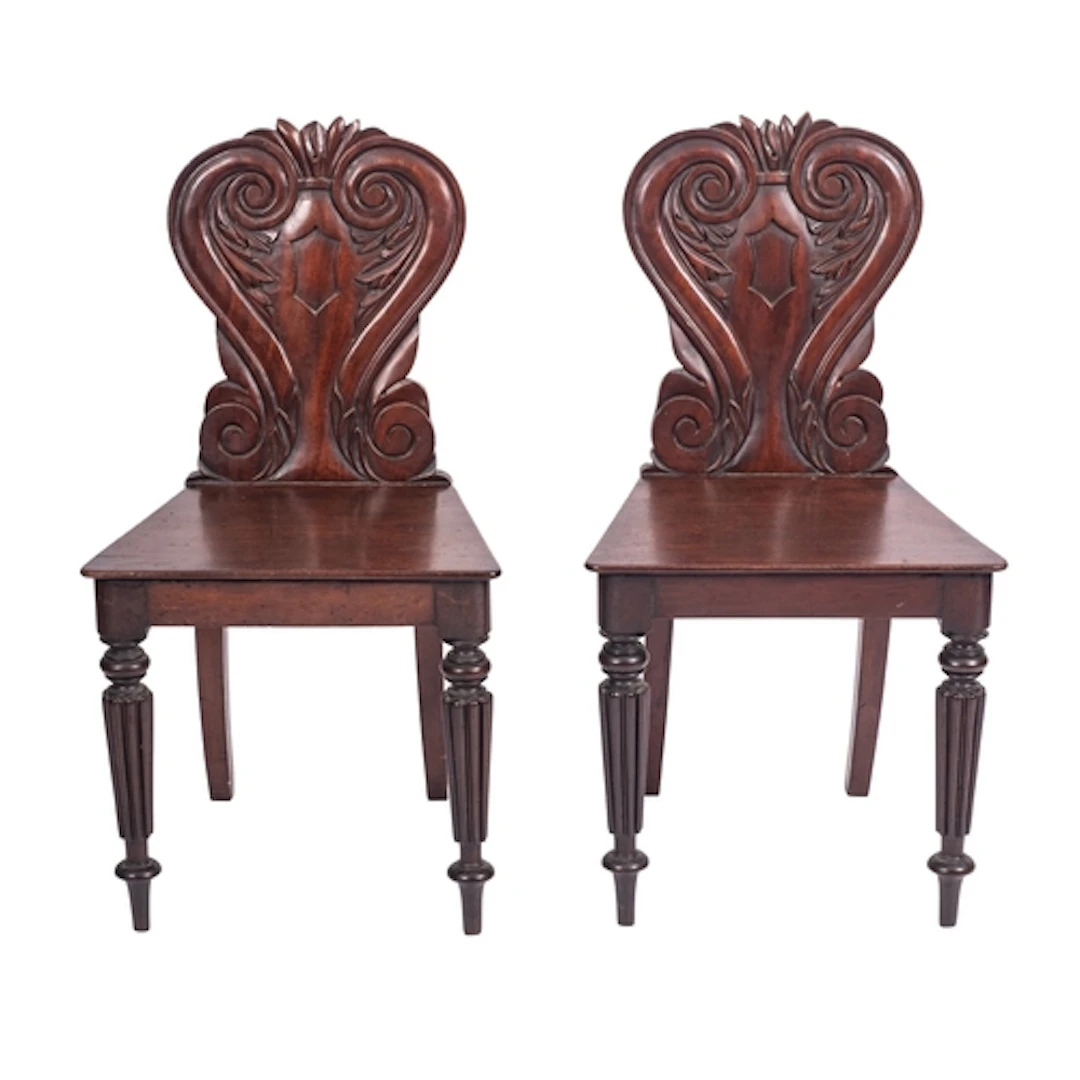 A pair of Regency mahogany hall chairs, circa 1815; the hear...